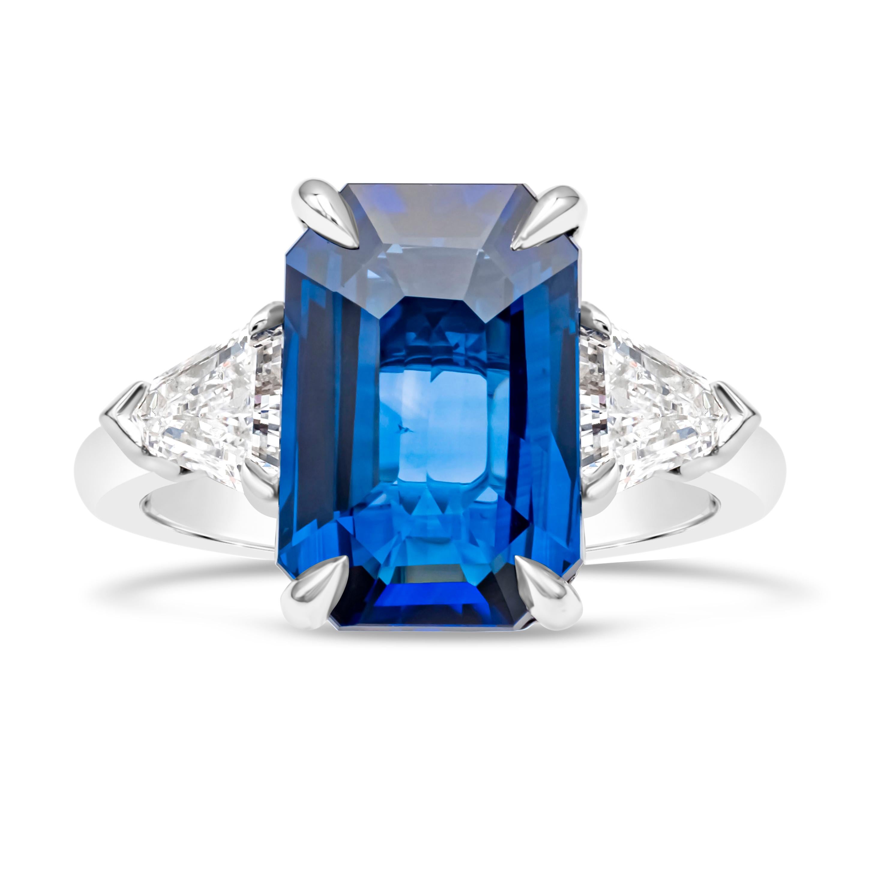 This wonderful and beautiful three stone engagement ring showcasing a GRS certified 5.04 carats emerald cut brilliant blue sapphire in the center, flanked by two shield shape diamonds on each side weighing 0.98 carats total, F Color and VS in