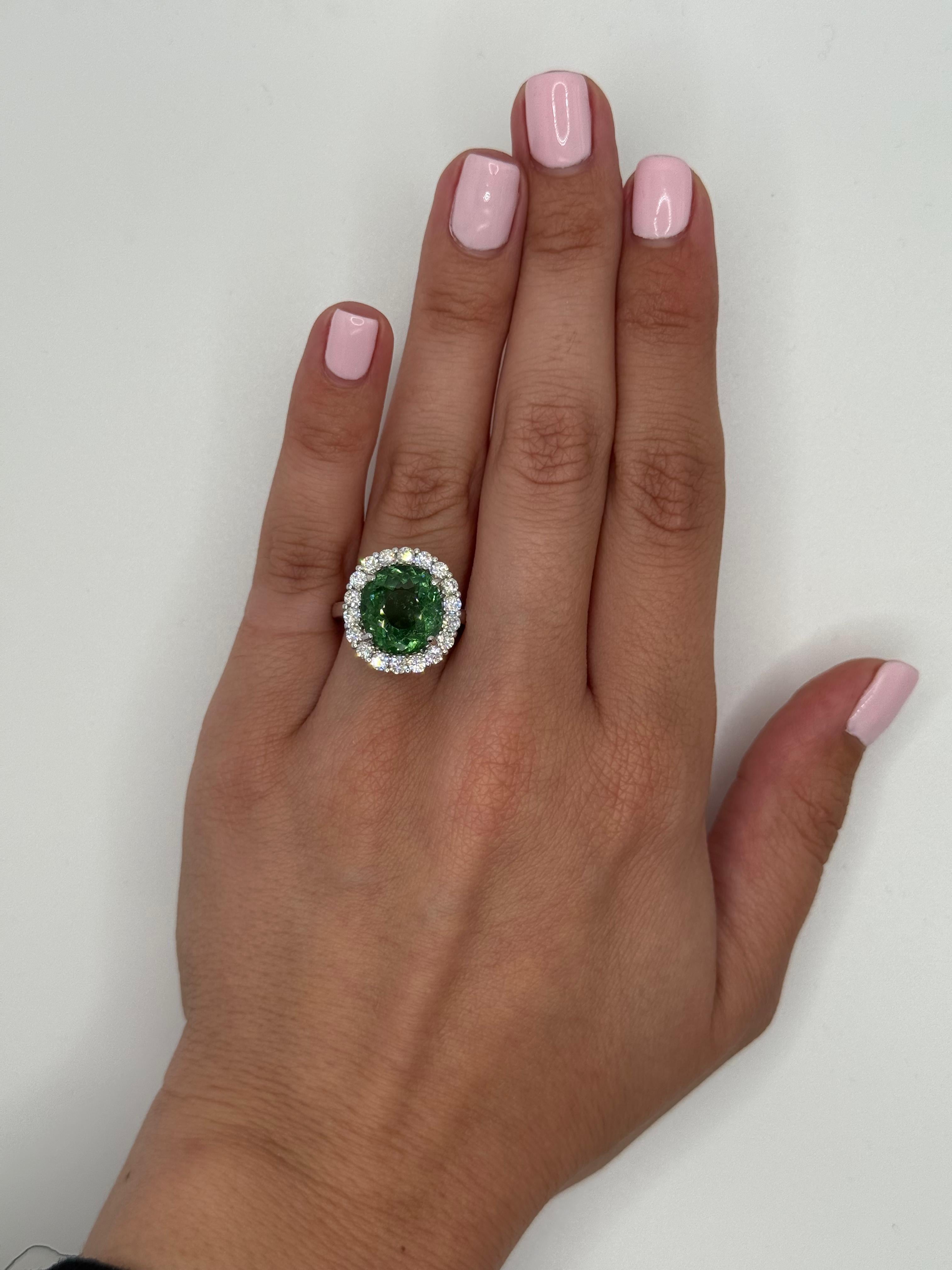 Kühn, strahlend und wahrhaft unvergesslich präsentiert sich dieser exquisite Halo-Ring mit einem seltenen ovalen Paraiba-Turmalin von 5,04 Karat, einem Edelstein, der für seinen intensiven grün-blauen Farbton und seine strahlende Brillanz bekannt