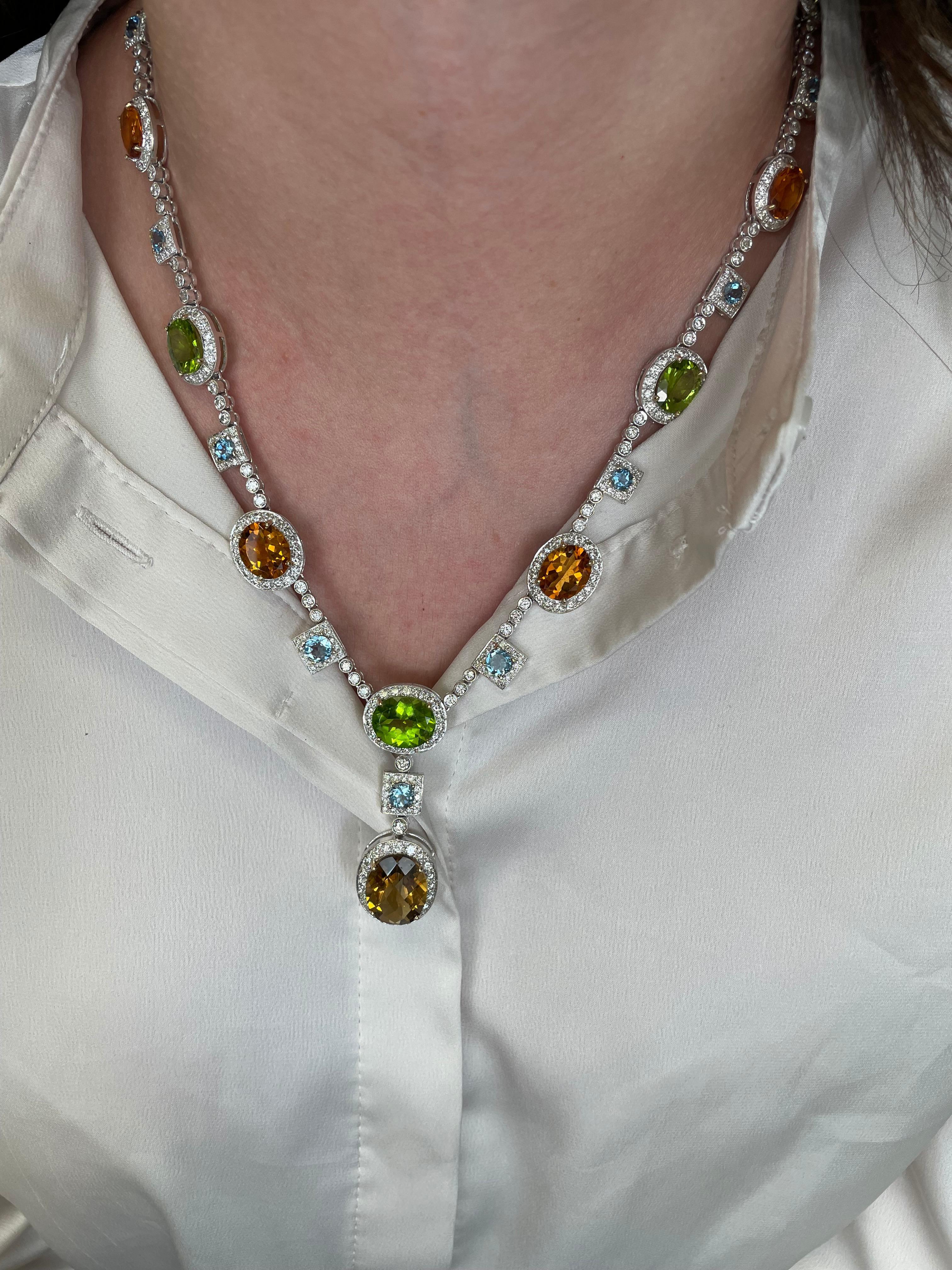 Statement multi colored stone and diamond drop necklace.
10.10 carats of round brilliant diamonds, approximately H/I color and SI clarity. 15.66 carats of oval peridot. 18.79 carats of oval citrine quartz. 5.85 carats of round aquamarine beryl.