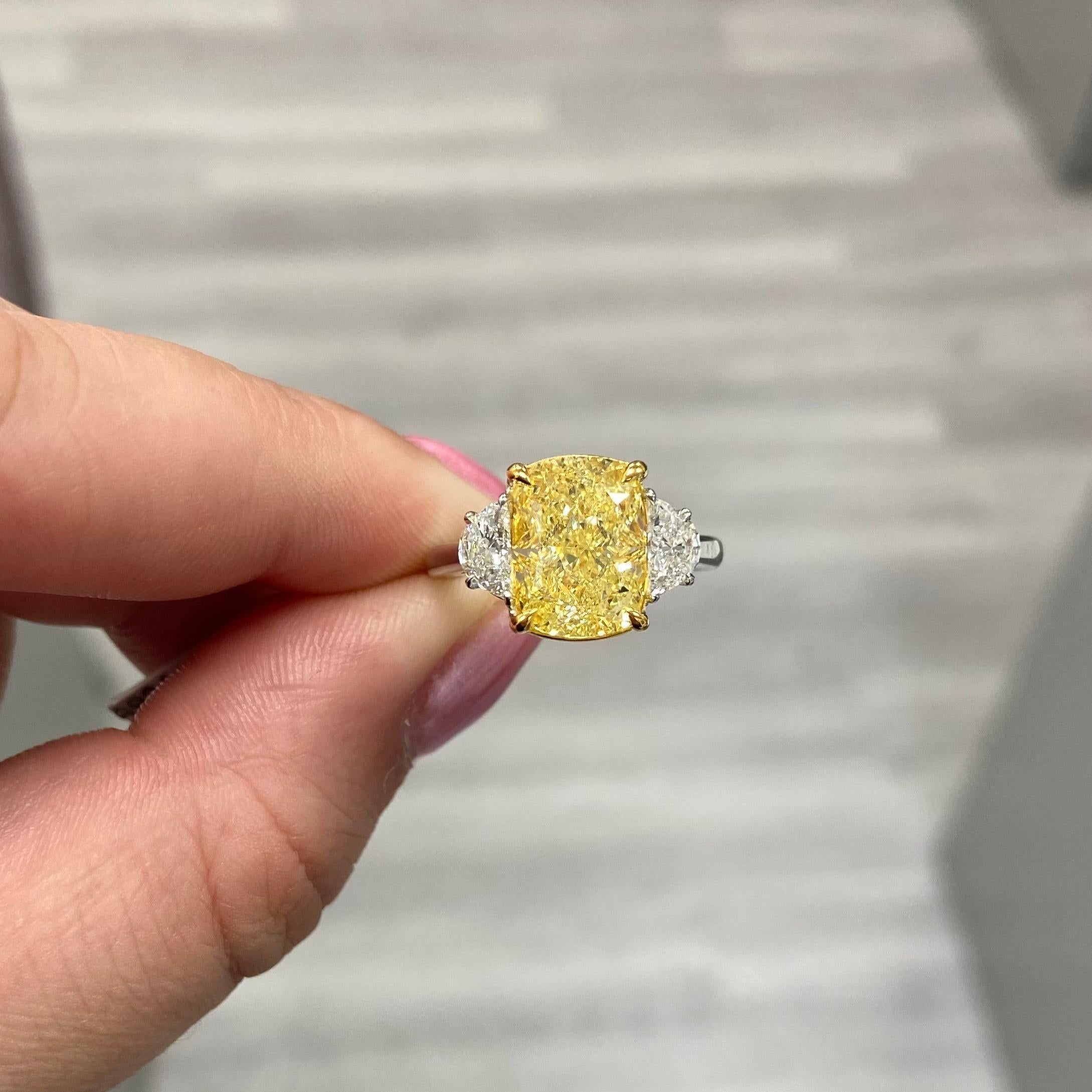 Very well laid out 5ct rectangular cushion Fancy Yellow VVS set in a handmade platinum ring topped with  18 karat yellow gold with a pair of 0.59ct total weight Half Moons F VS quality.
Very lively and charming piece.
This piece can be viewed before