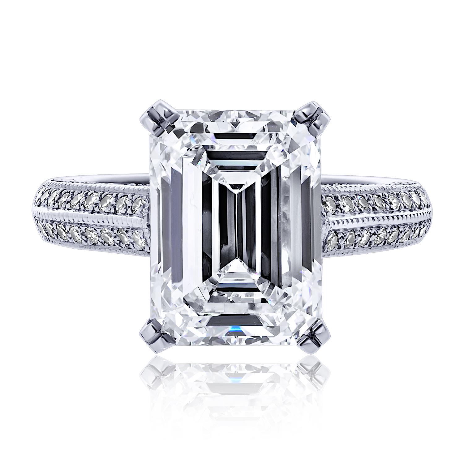 A breathtaking statement of timeless elegance, this platinum engagement ring showcases a stunning 5.04 carat emerald cut diamond, certified by GIA as E color and VS2 clarity—an exceptional combination of near colorless brilliance and remarkable