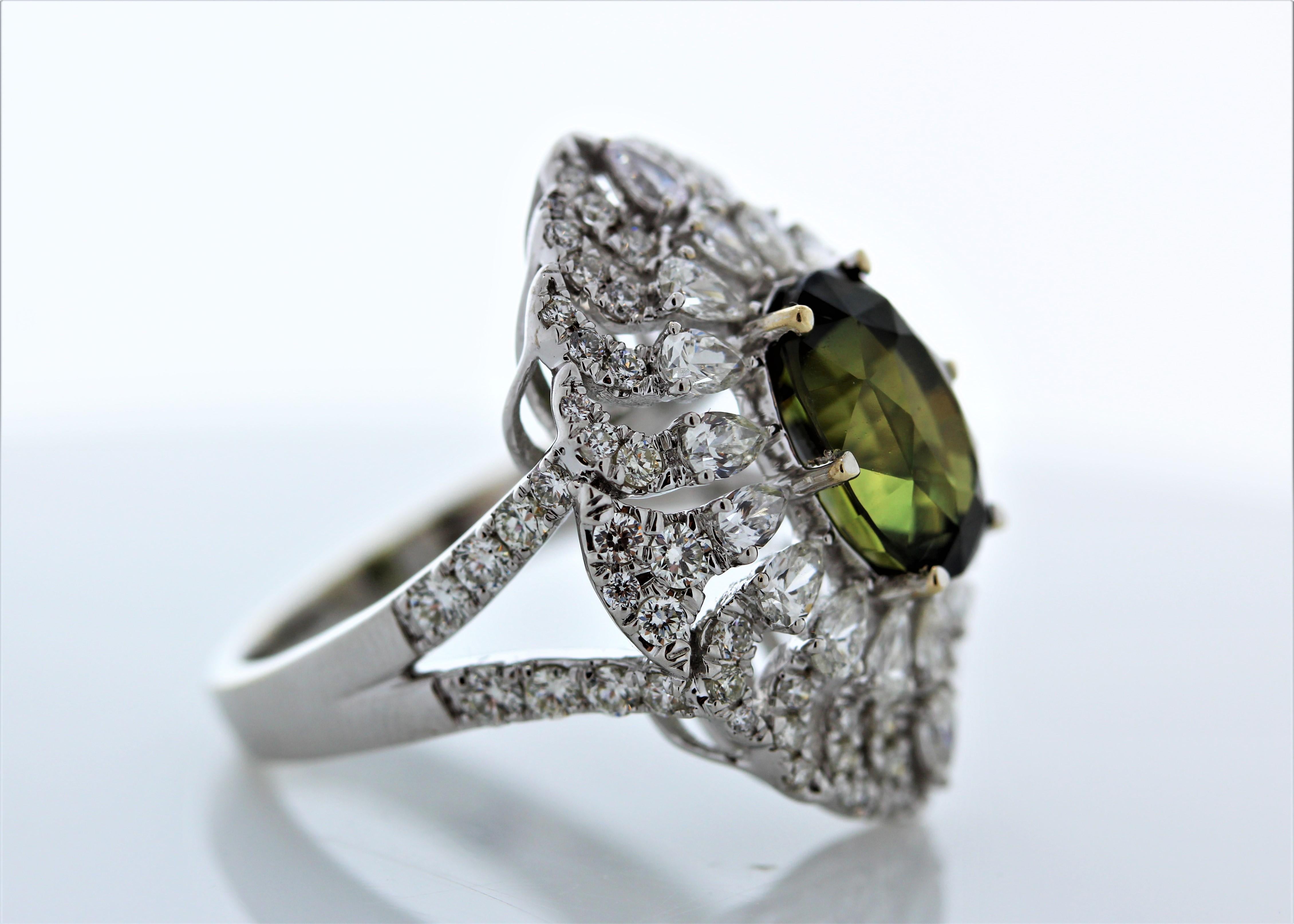 This unique halo cocktail ring features a oval cut green sapphire weighing 5.04carat. This green sapphire takes center stage in a 14k White Gold  setting. Its gem source is Sri Lanka; its transparency and luster are excellent. A total of 92 mixed