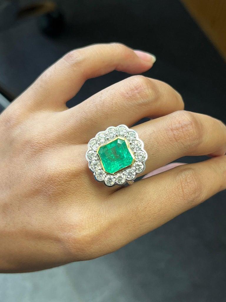 Cette bague remarquable met en valeur une impressionnante émeraude de 5.05 carats, qui rayonne d'une teinte verte enchanteresse et extrêmement rare. Bien que les photos fournies permettent de saisir son allure, elles ne parviennent pas à rendre