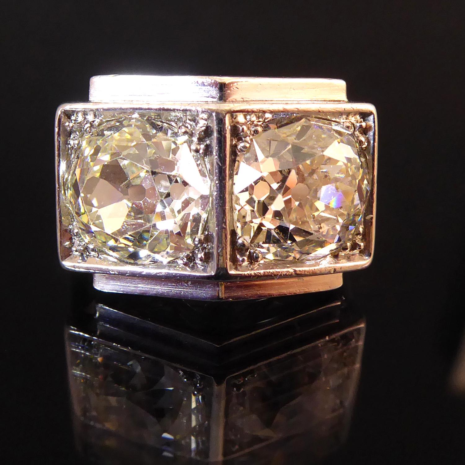 A spectacular vintage diamond two stone ring set with a pair of old European cut diamonds totalling 5.05ct in square collet settings with a polished bevel edge.  One diamond measures approx 8.90m x 8.40mm x 5.08m deep and one approx. 8.96mm 8.50mm x