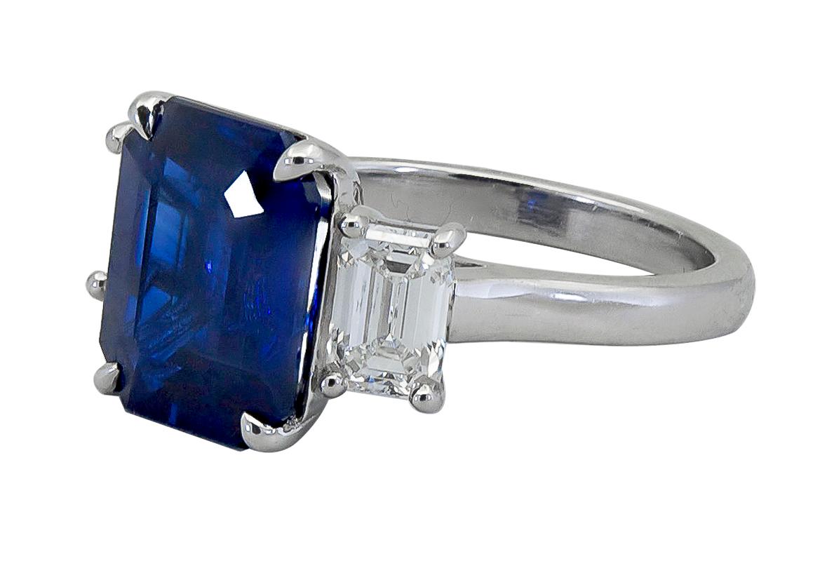 A timeless three-stone engagement ring style showcasing a vibrant emerald cut blue sapphire, flanked by emerald cut diamonds on either side. Set in traditional polished platinum mounting.
Emerald cut blue sapphire weighs approximately 5.86