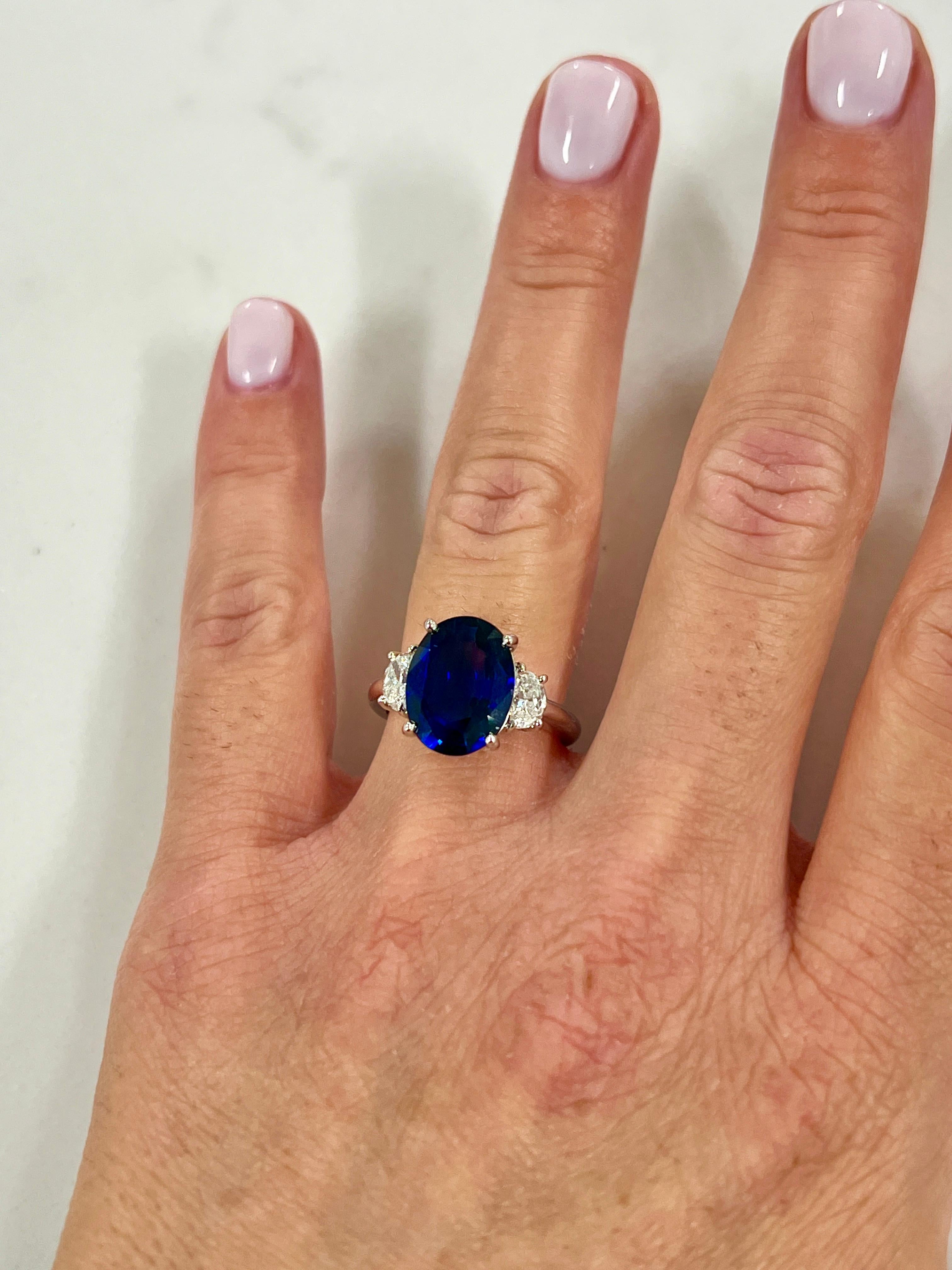 Stunning 5.05 ct Oval Ceylon natural sapphire ring. The sapphire comes with a CDC certificate stating the origin of Ceylon and heat only. The sapphire is set with two half-moon diamonds weighing .60 ct total and graded G-H in color and VS2-SI1 in
