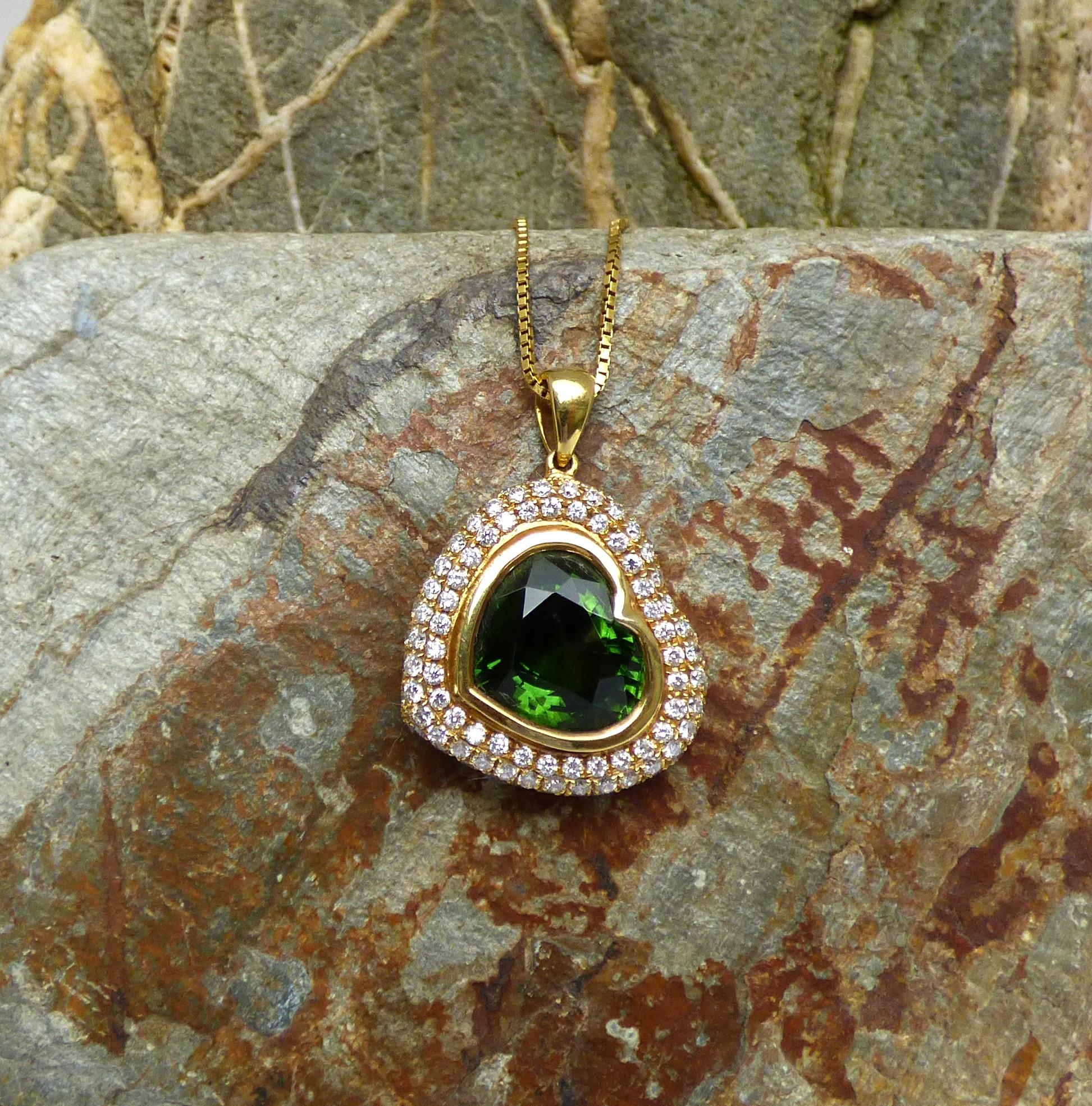 This heart shaped pendant drops at an angle from the chain.  The heart shaped green Tourmaline (5.50ct.) is full of brightness and colour.  The Tourmaline is surrounded by three rows of Diamonds with a total diamond weight of 1.15ct.  The total