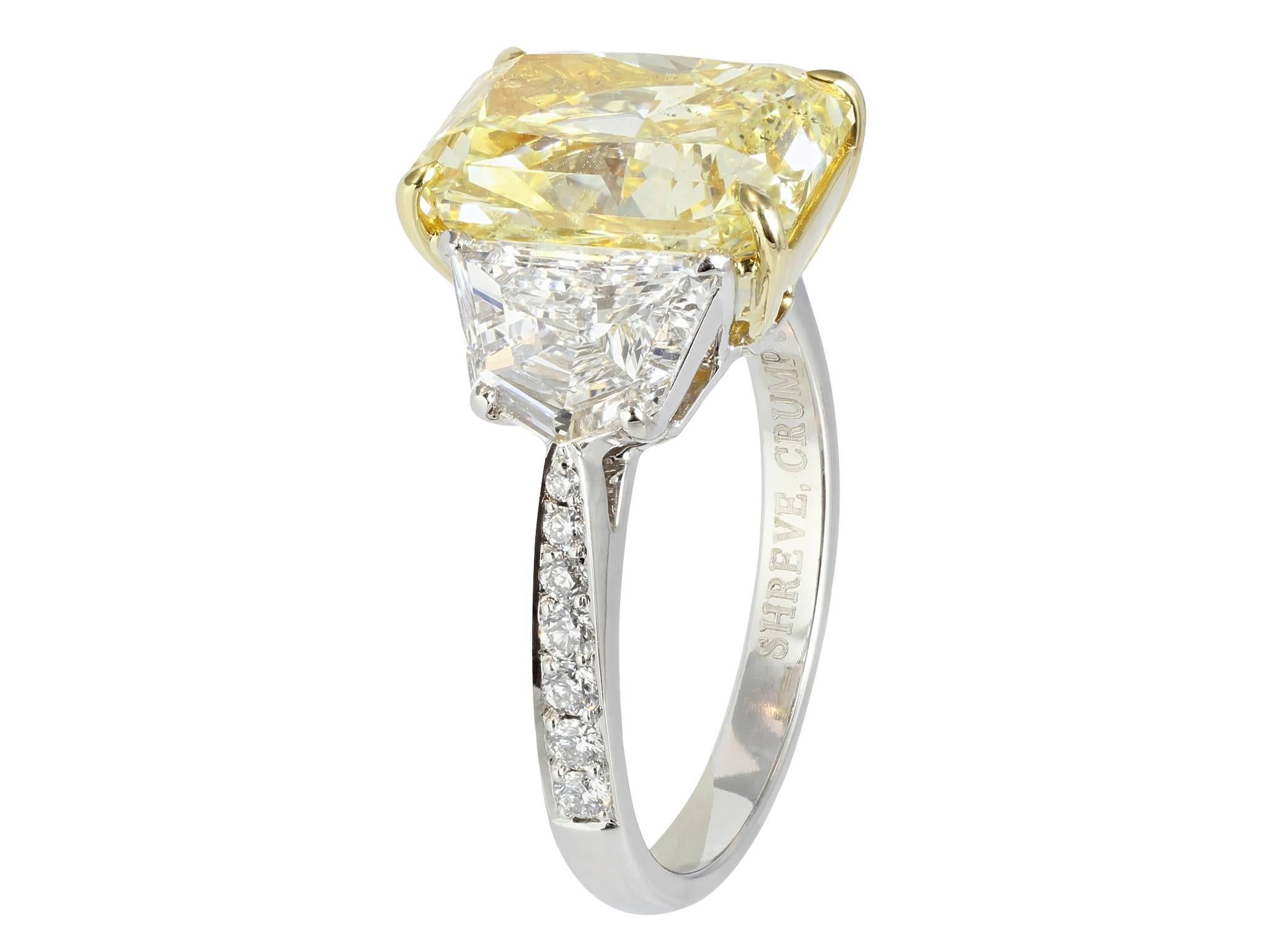 Custom made platinum and 18 karat yellow gold 3 stone ring consisting of 1 rectangular radiant cut canary diamond weighing 5.07 carats having a color Fancy Intense Yellow measuring 11.13 x 8.34 x 6.01 mm, with GIA color report #2155529810, the