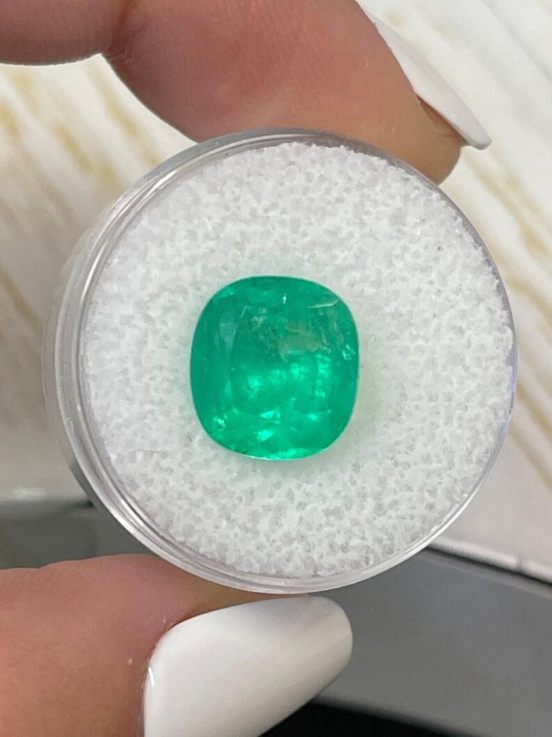 Stone: Emerald
Weight: 5.07-carats
Shape: Cushion Cut
Clarity: Semi-Transparent
Luster: Very Good
Color: Medium Yellowish Green
Measurements: 11.26mm x 10.40mm x 7.73mm
Geographic Origin: Colombia
Treatment: Natural, Oiling

Comments: Due to their