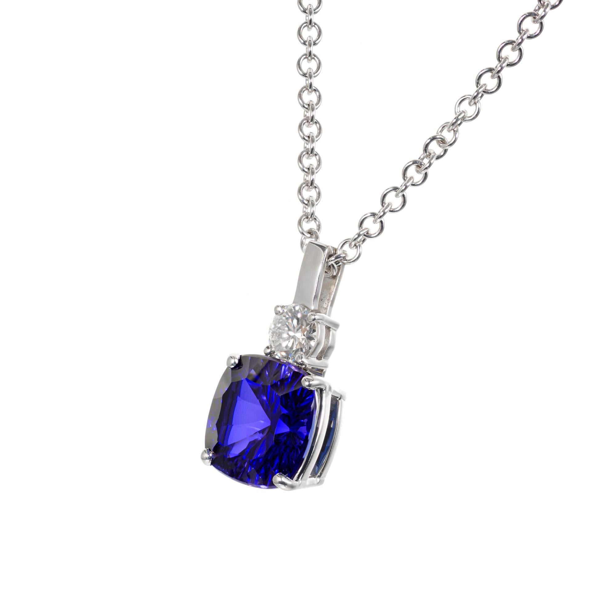 Cushion shape 5.07 carat bright purple blue tanzanite, accented by one round brilliant cut diamond in a 14k white gold setting and chain.  

1 cushion cut blue tanzanite VS2, approx. 5.07cts
1 round brilliant cut diamond H-I VS2, approx. .38cts
14k