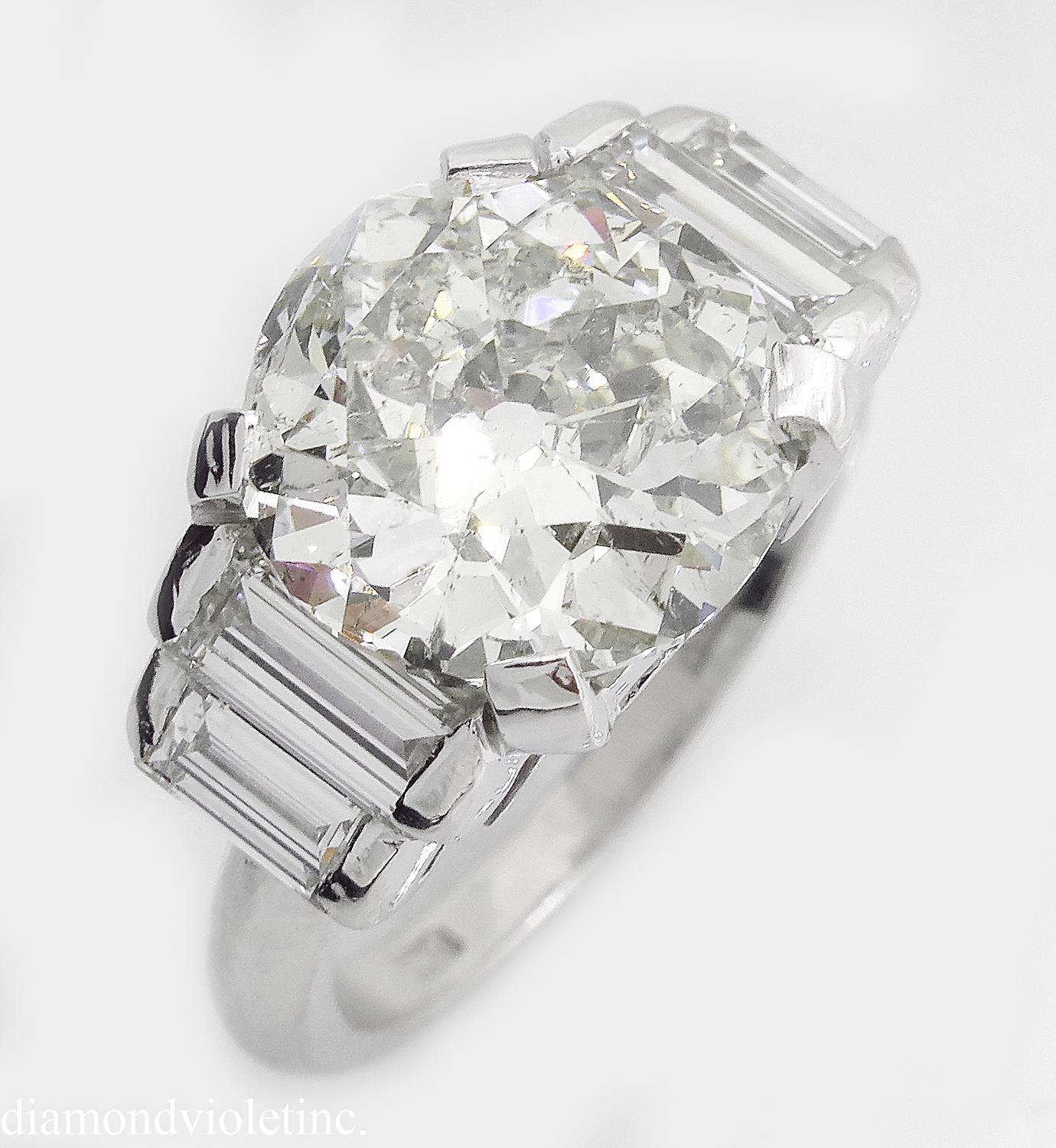 A Breathtaking Estate Vintage HANDMADE 18K White Gold (stamped) Engagement ring dazzles EGL USA certified 4.01ct Old European center diamond in J-K color SI2 clarity; with measurements of 10.16x10.12x5.50mm.
It is set with 4 Vertically set Step cut