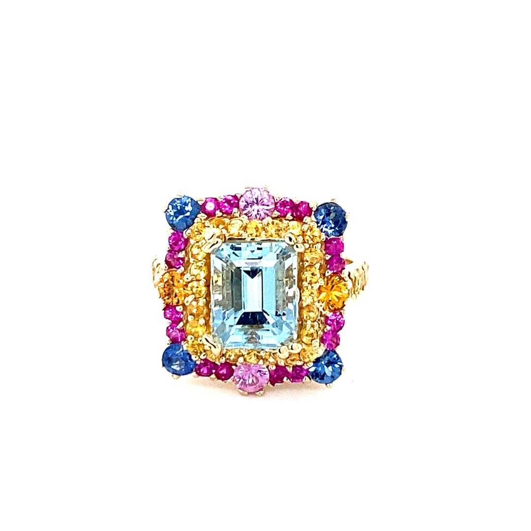 5.97 Carat Aquamarine Sapphire Diamond 14K Yellow Gold Cocktail Ring

Cette bague est ornée d'une magnifique aigue-marine taille émeraude de 2,50 carats, entourée de 56 saphirs bleus, roses et jaunes pesant 2,59 carats.  L'aigue-marine et le saphir