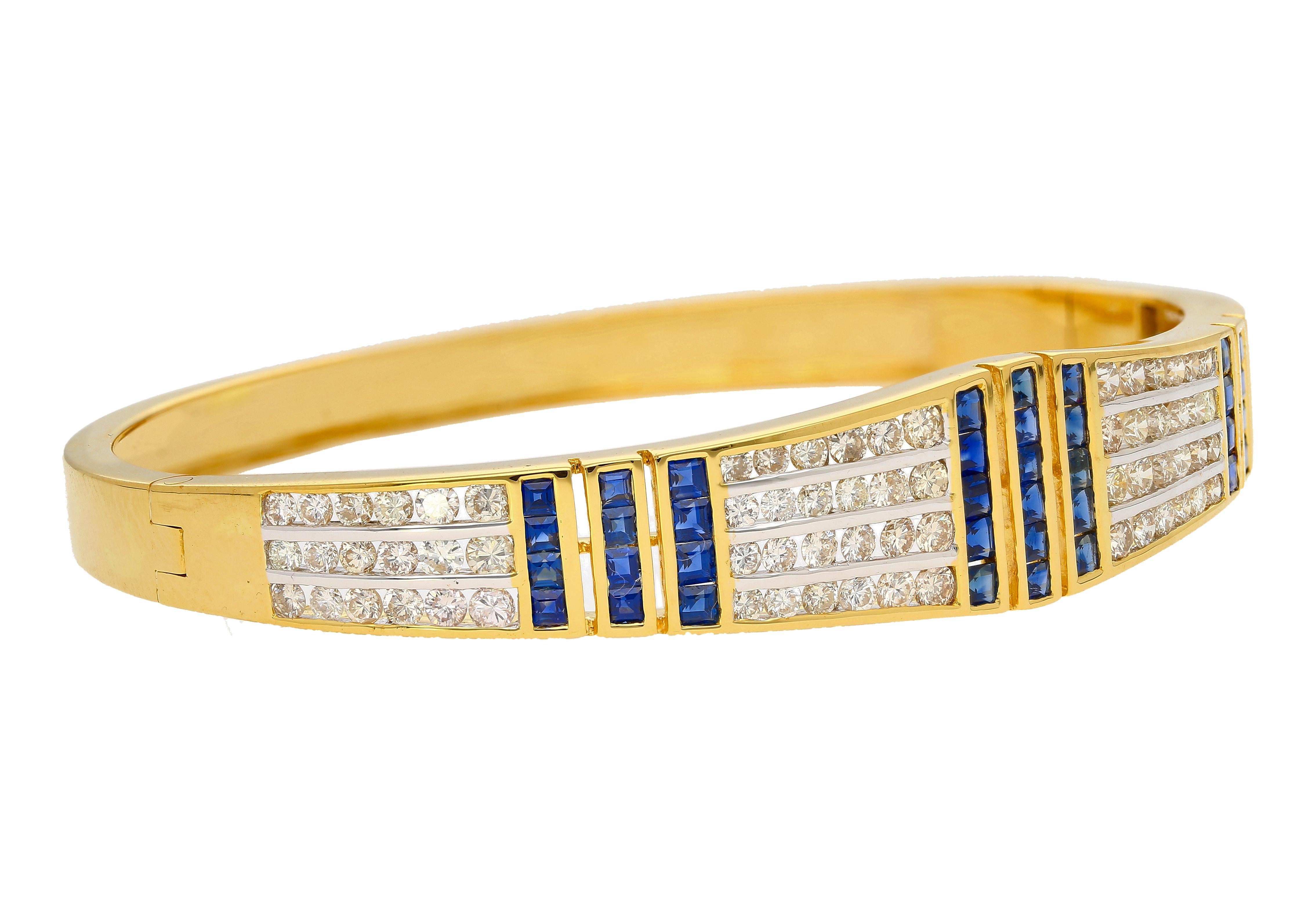 5.09 carat total blue sapphire and white diamond bangle bracelet. Adorned with 40 baguette cut natural blue sapphires (2.24 cttw) and 84 round cut white diamonds (2.85 cttw). The gemstones are all bezel/channel set. The face width of the bangle is
