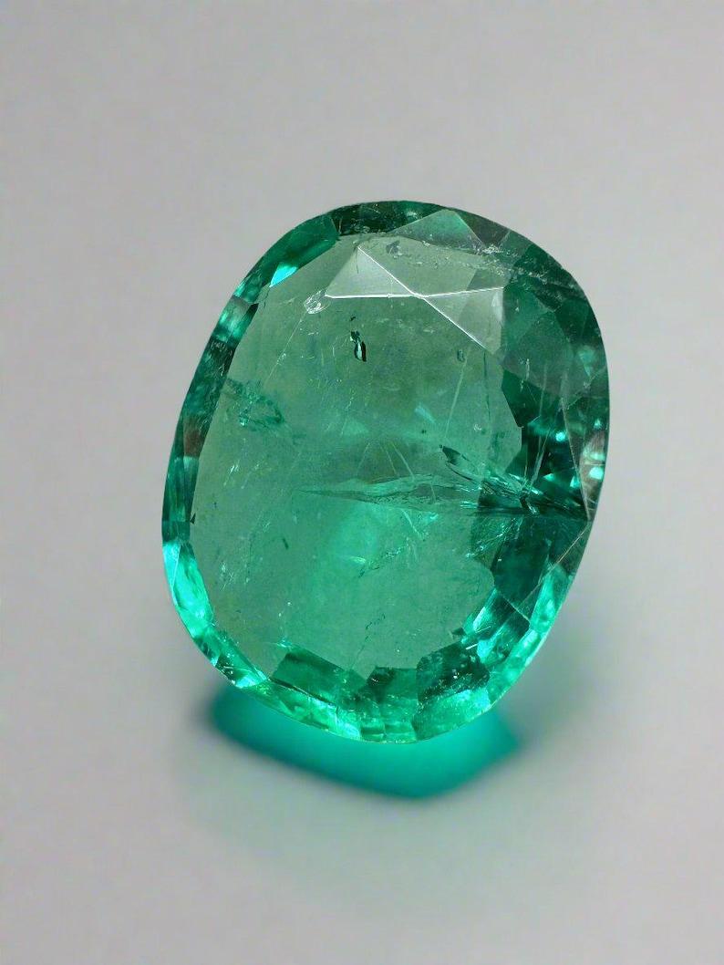 Stone: Emerald
Weight: 5.09-carats
Shape: Cushion/Oval Cut
Clarity: Transparent
Luster: Very Good
Color: Medium Bluish Green
Measurements: 13.31mm x 10.98mm x 5.36mm
Geographic Origin: Colombia
Treatment: Natural, Oiling

This emerald has natural