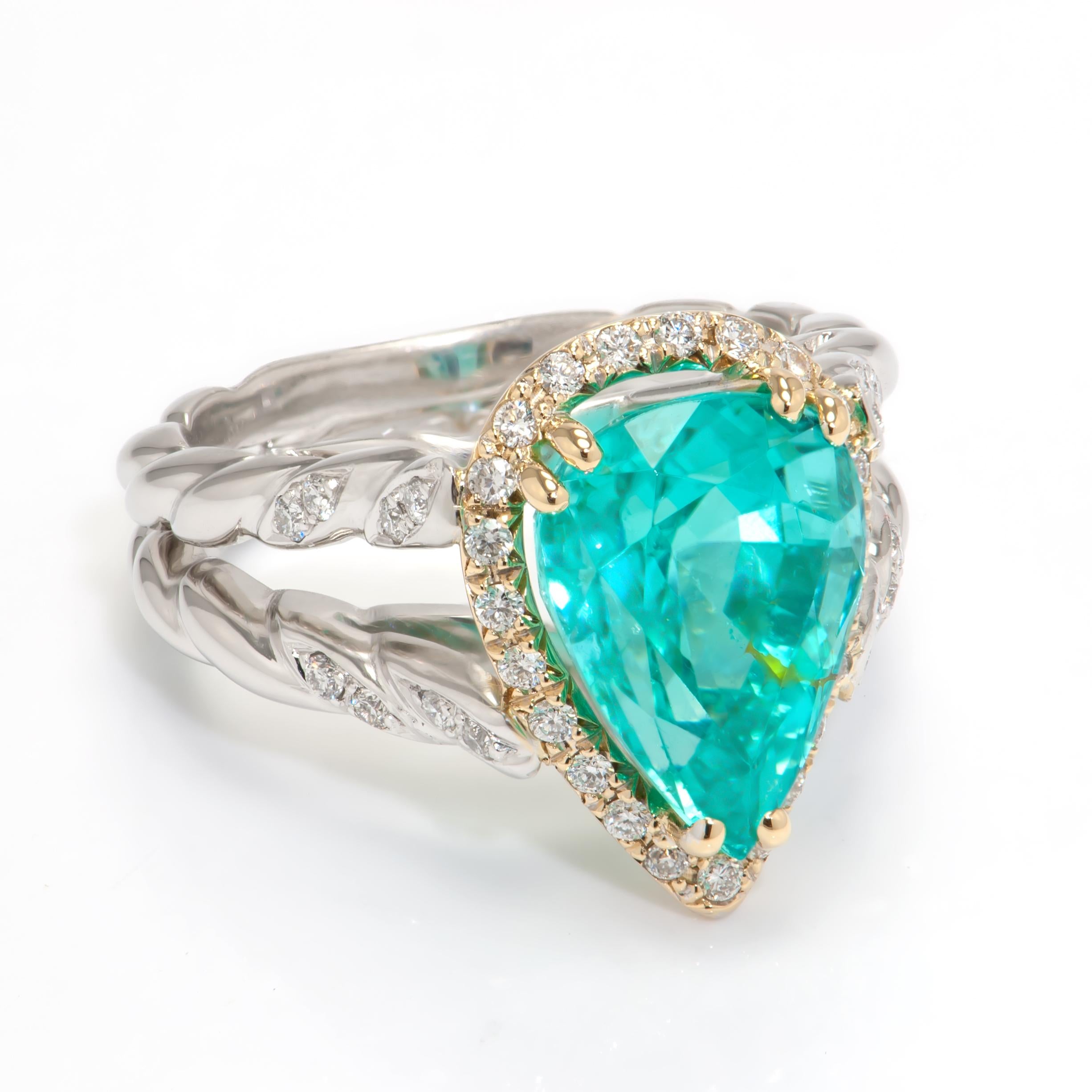 Magnificent Paraiba Tourmaline and Diamond Cocktail Ring. Centering a Beautiful 5.09ct Pear shaped Paraiba Tourmaline; measuring approx. 12.06mm x 9.10mm x 7.60mm surrounded by 23 round brilliant cut diamonds, 0.22tctw. Hand crafted in Platinum and