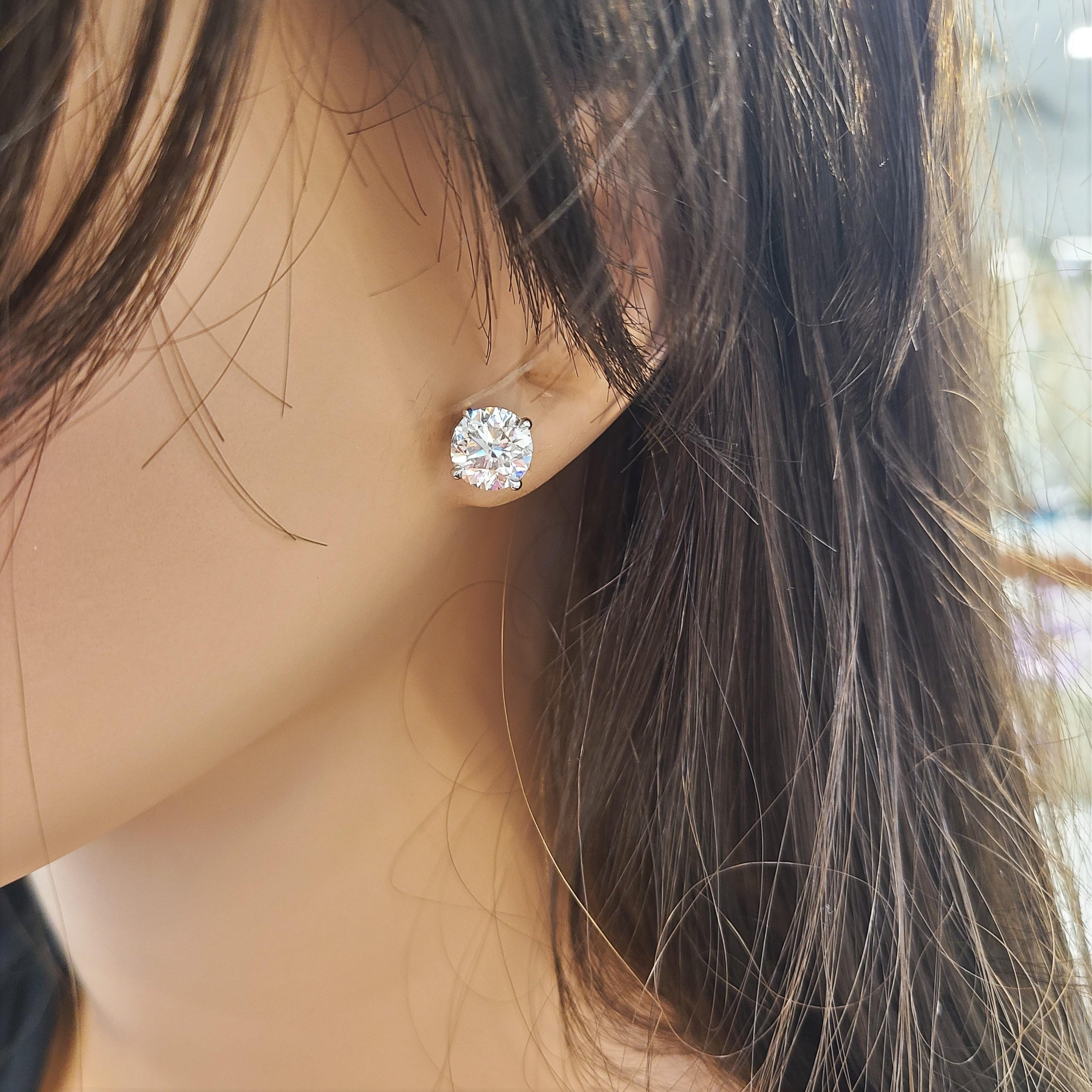 Stunning 14 Karat white gold handmade earrings featuring 2 round brilliant cut diamonds weighing 5.09 carat total J color VS1-VS2 clarity. The stunning earrings measure 8.54 - 8.50 mm in diameter, these gorgeous earrings are classic and timelessly
