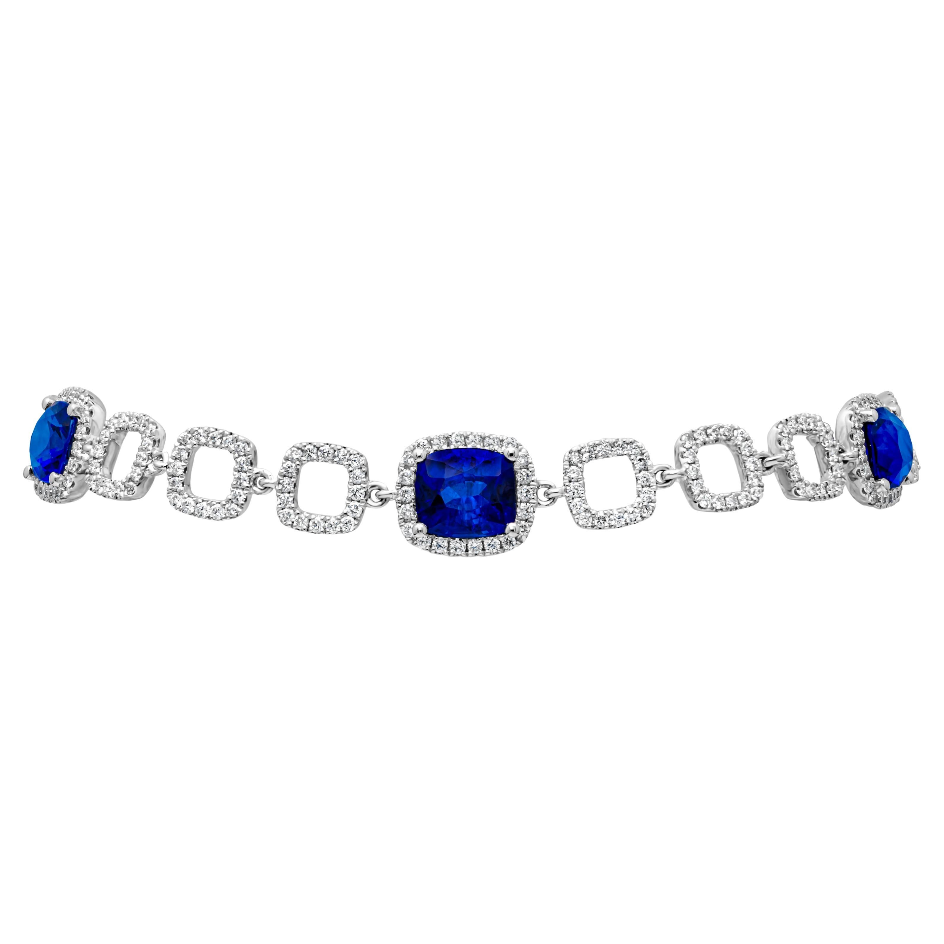 A fashionable and stunning tennis bracelet showcasing a color-rich 5 cushion cut blue sapphires weighing 5.09 carats total, set in a classic four prong basket setting and surrounded by brilliant round cut melee diamonds in a halo design. Elegantly