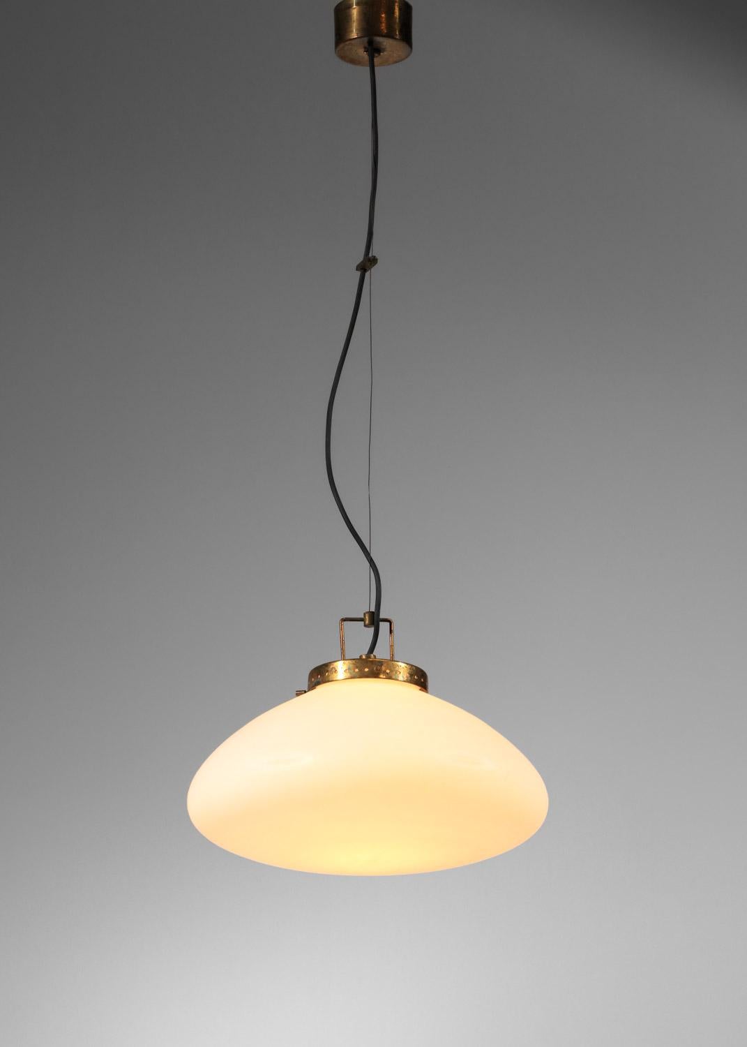 Italian hanging lamp from the 50s, attributed to the Stilnovo publishing house. Saucer-shaped lampshade in opaque white opaline, hanging system and ceiling canopy in solid brass. The overall height of the chandelier can be adjusted using the hanging
