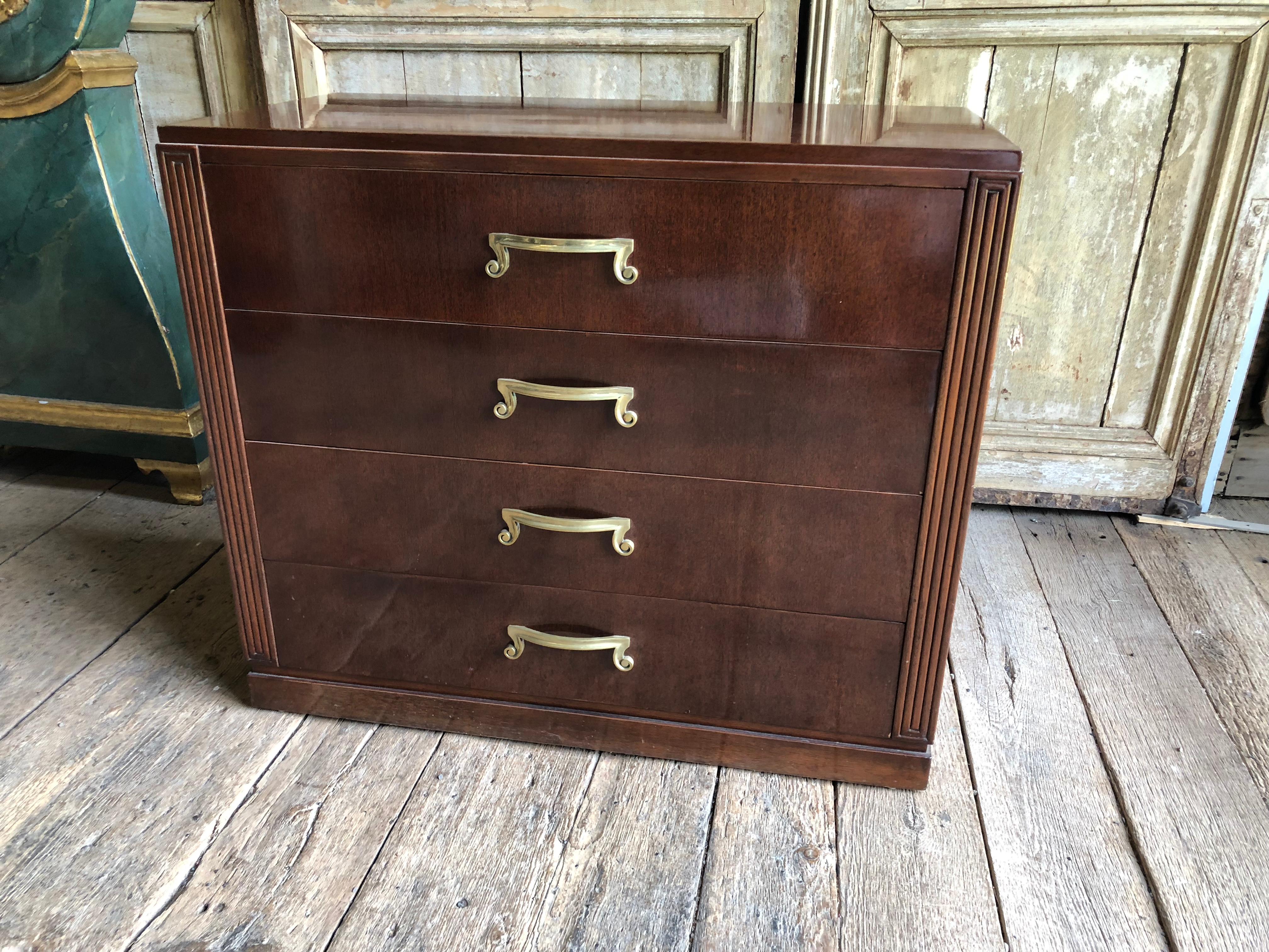 A 1950s modern mahogany chest of drawers with decorative plates brass handles, signed on interior of top drawer “Orsenigo Furniture, New York”.