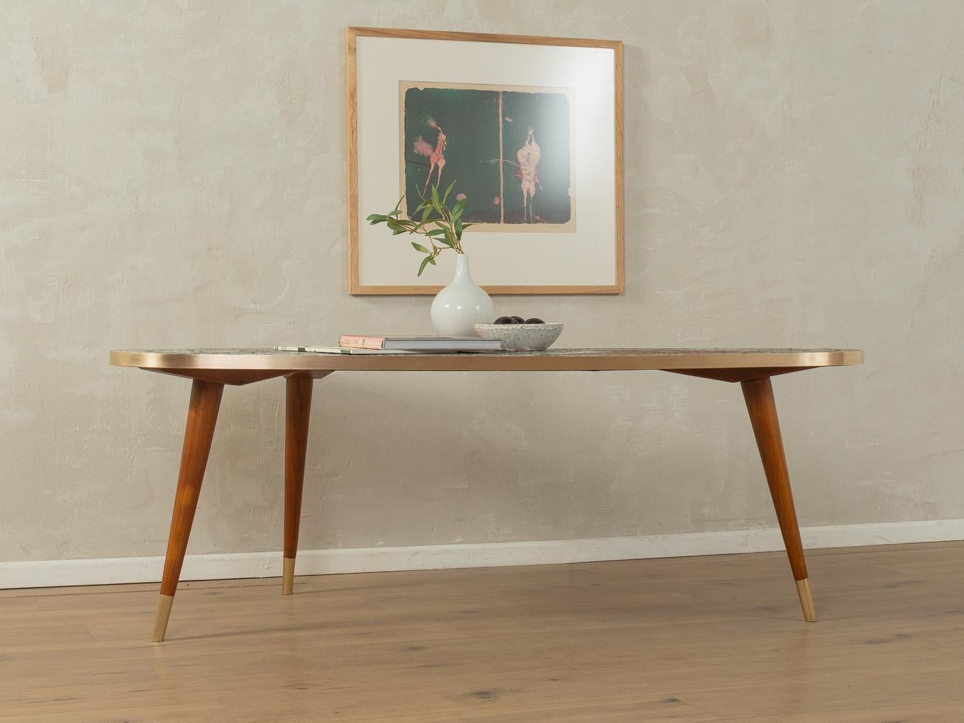 Tavolino unico degli anni '1950. Piano del tavolo di alta qualità con bordo in ottone e mosaico nei toni del bianco, grigio, rosso e nero e piedi in faggio massiccio con tappi in ottone.

Caratteristiche di qualità:
ottima lavorazione
materiali di