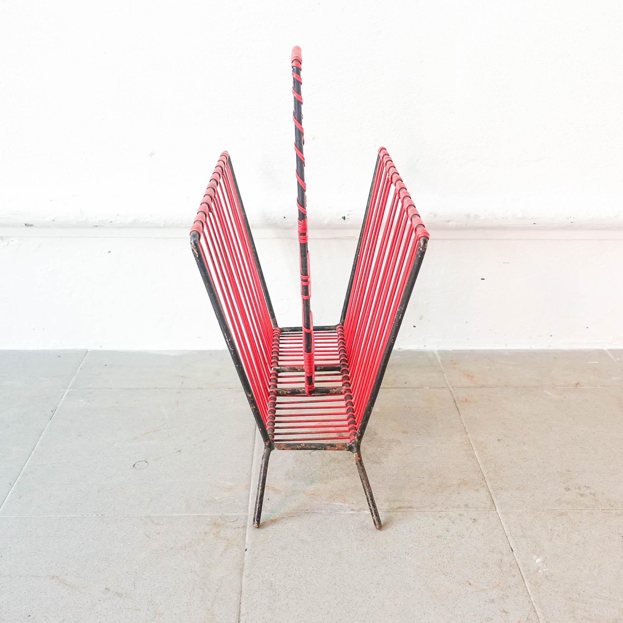 This Spaghetti Magazine rack was designed and produced during the 1950's. 
It is made of bent metal bar painted in black and plastic-coated braid in red color. Metal has paint splinters.
In original and good condition.