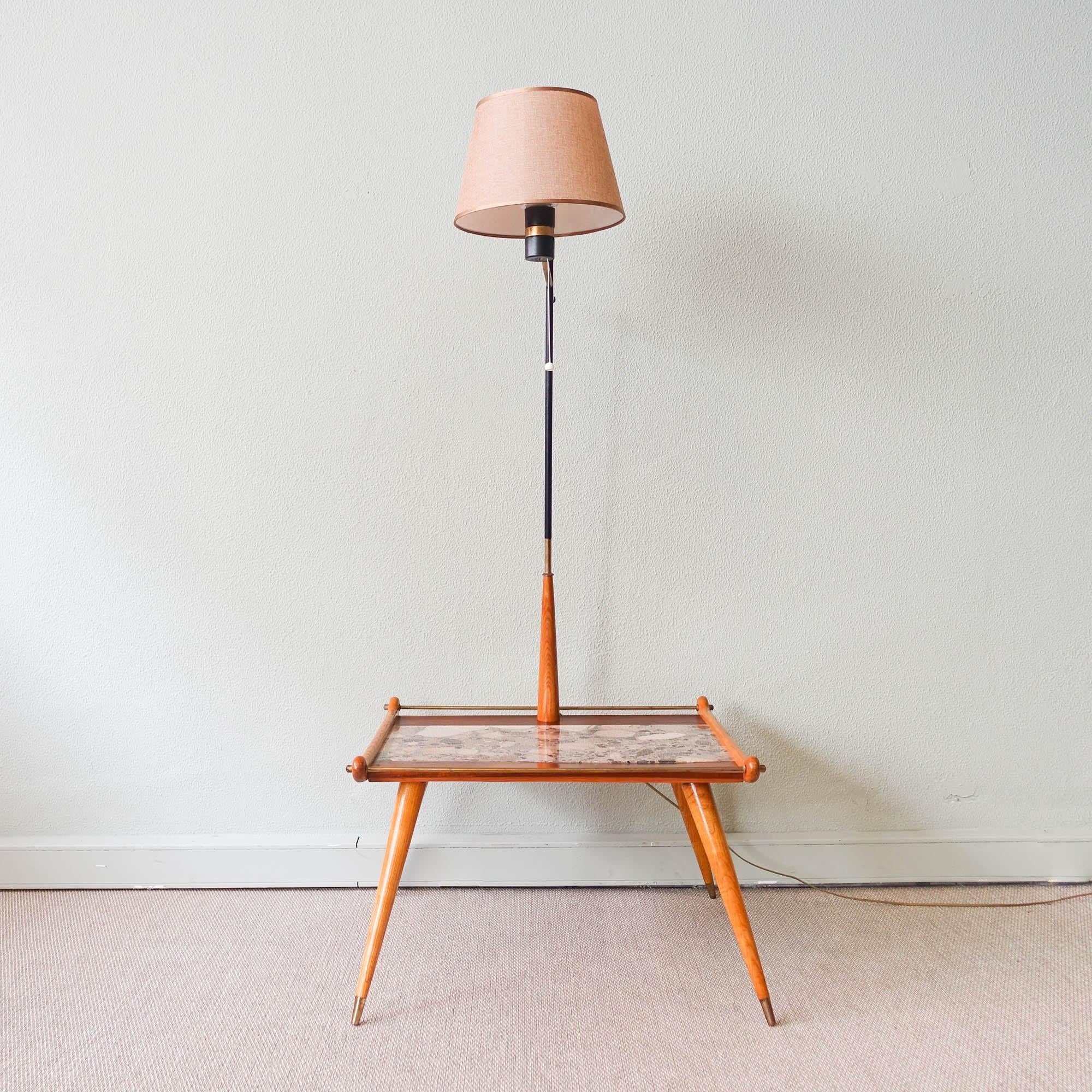 This floor lamp with intergrated table is original from the 1950's and was produced in Portugal. It has the original lampshade. The feet are in ash with brass tips and the top of the table is in Undianuno wood and 