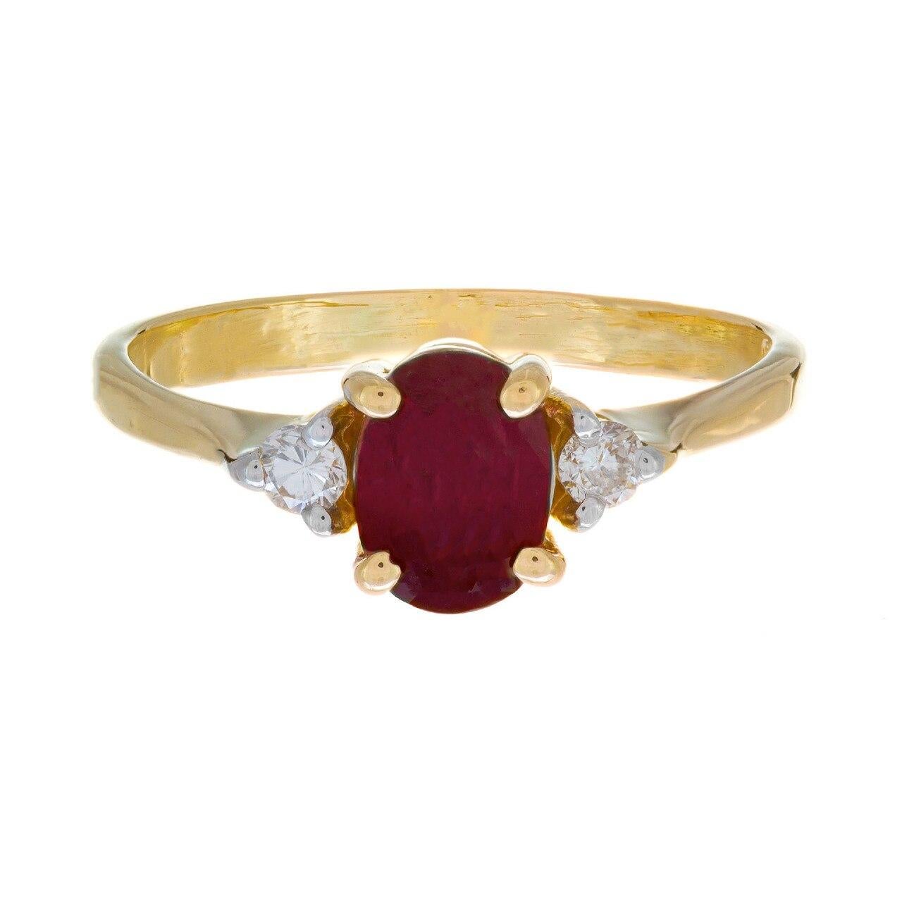 Ruby and diamond engagement ring. Oval center ruby with two round brilliant cut side diamonds in 18k yellow gold three-stone setting.  

1 oval red ruby, MI approx. .51cts
2 round brilliant cut diamonds, I SI2-I approx. .6cts
Size: 4.75 and