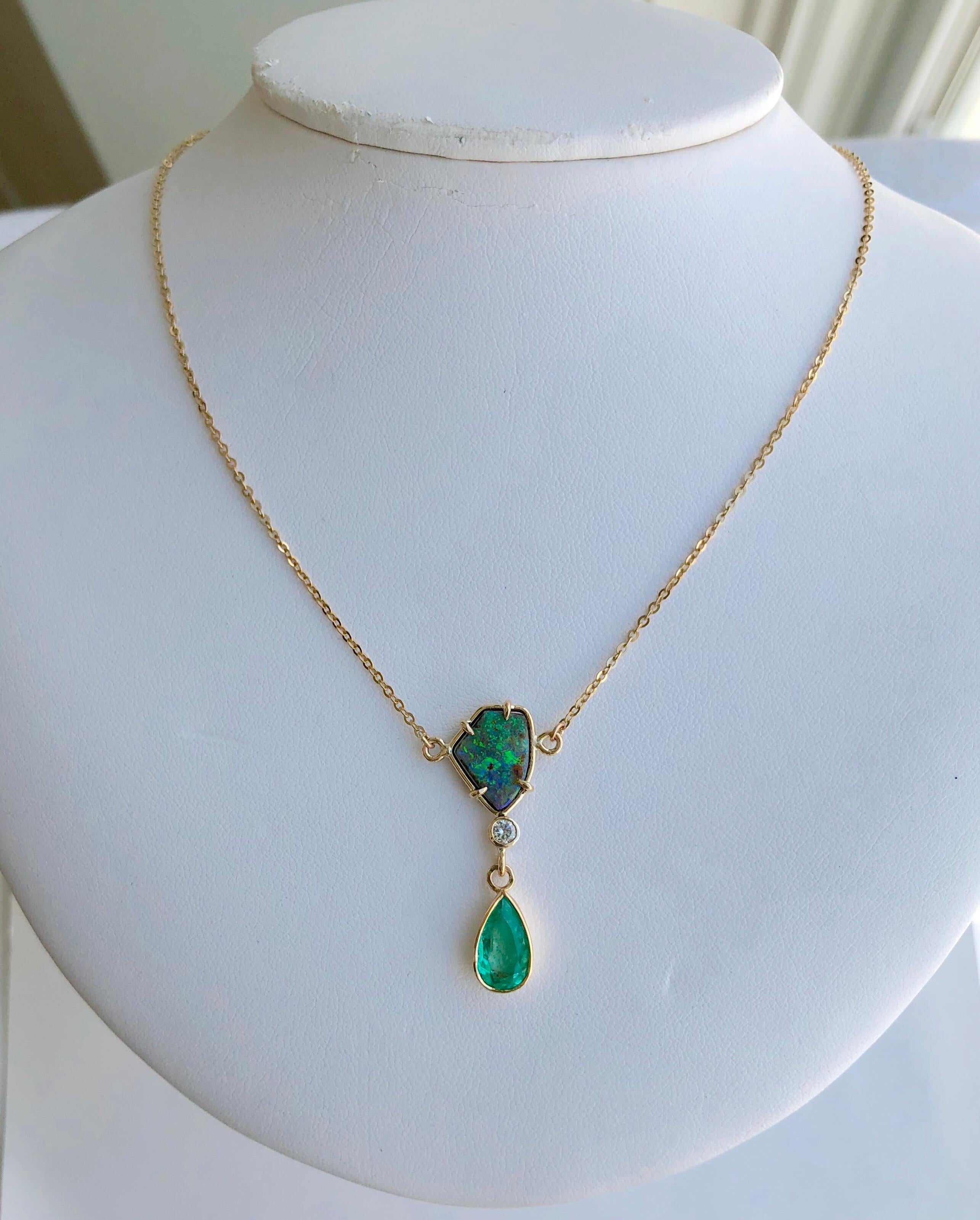 This stylish necklace featuring a gorgeous 1.50 carat natural Colombian emerald pear cut and a free form Australian boulder opal 3.50 carat with great play of colors. The pendant necklace also feature a round diamond approx 0.10cts. This beautiful