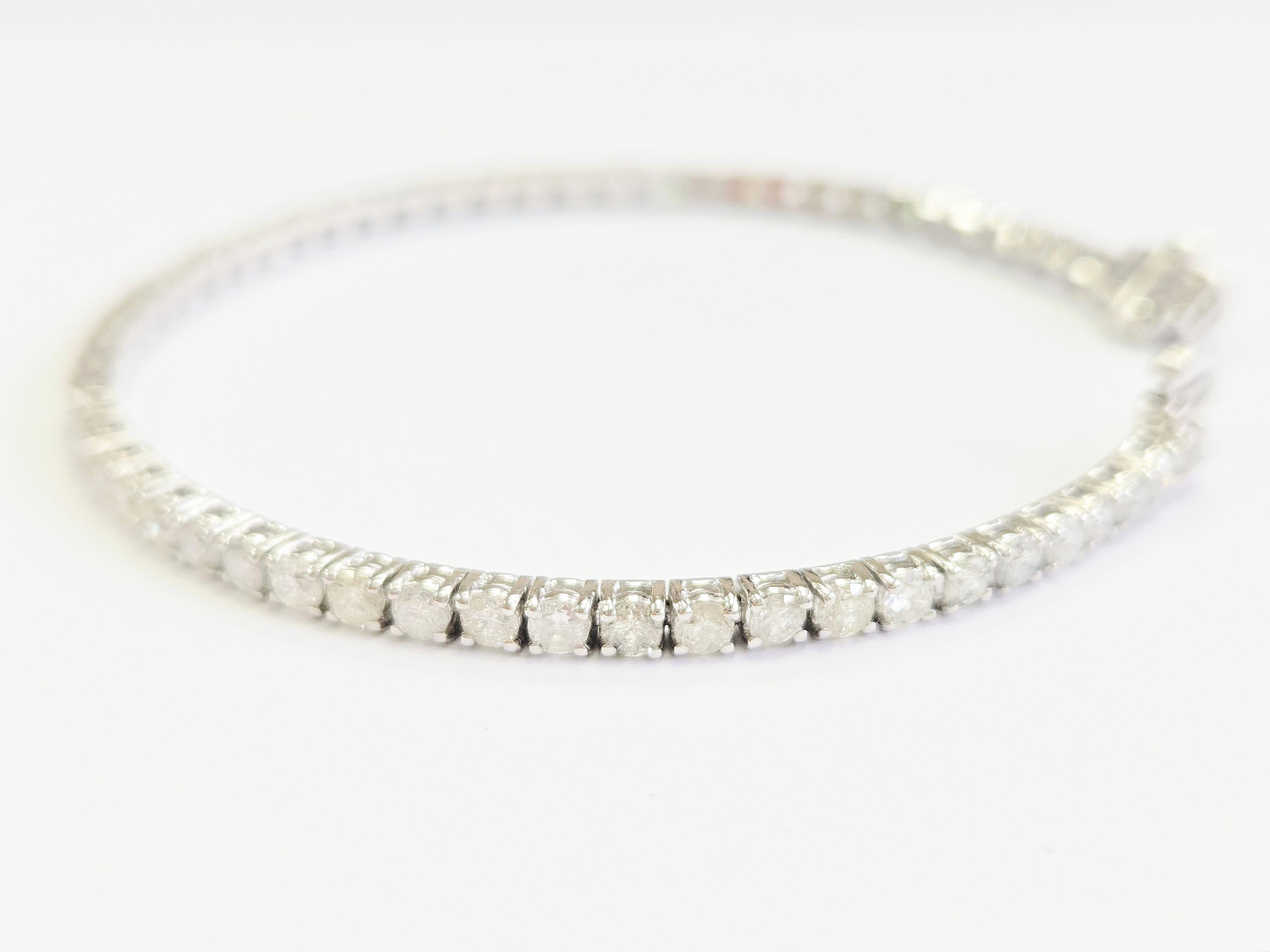 This exquisite tennis bracelet features round brilliant cut white diamonds, known for their exceptional brilliance and sparkle. Set in a classic four-prong style, the diamonds are carefully secured to maximize light reflection for an unmatched