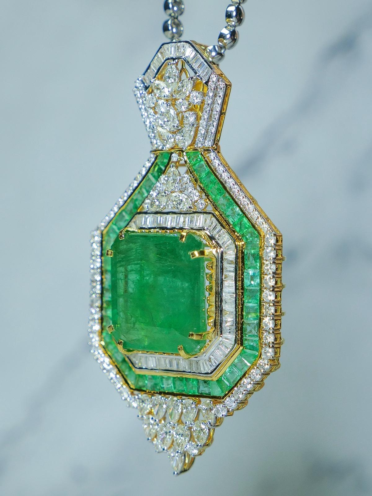 Sie werden keinen anderen Anhänger finden, der so schön ist wie dieser. Eine riesige  51,05 Karat natürlicher sambischer Smaragd, gefasst in einem einzigartigen Design, umgeben von sechzig gefassten Diamanten im Baguetteschliff und vierundvierzig