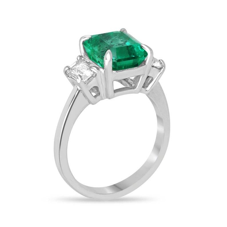 Unser exquisiter Dreisteinring ist eine atemberaubende Verschmelzung von Eleganz und Luxus. Der aus 18-karätigem Weißgold gefertigte Anhänger ist mit einem 4,09-karätigen kolumbianischen Smaragd besetzt, der mit seinem lebendigen, sattgrünen Farbton