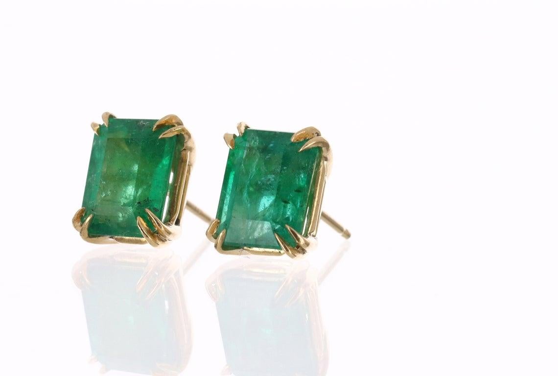 Featured here is a beautiful set of emerald cut, emerald studs in fine 18K yellow gold. Displayed are rich-green emeralds with very good transparency, accented by elegant double claw prongs, allowing for the emerald to be shown in full view. The