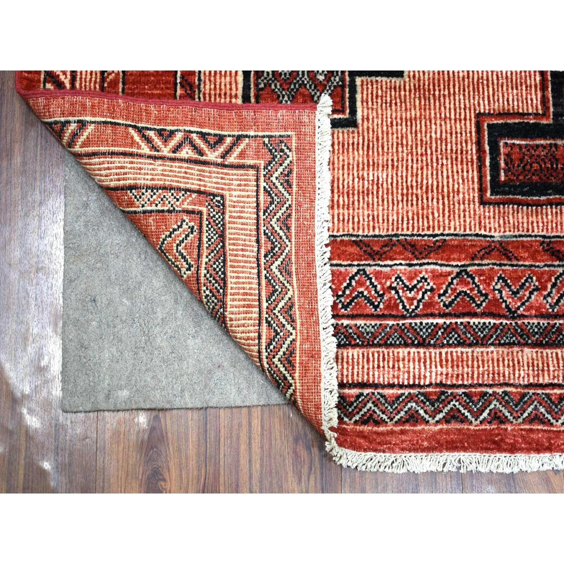 Il s'agit d'un véritable tapis oriental en laine nouée à la main Red Peshawar à motifs géométriques complexes et à couleurs vives. Il a été noué pendant des mois et des mois selon des techniques de tissage séculaires par des artisans