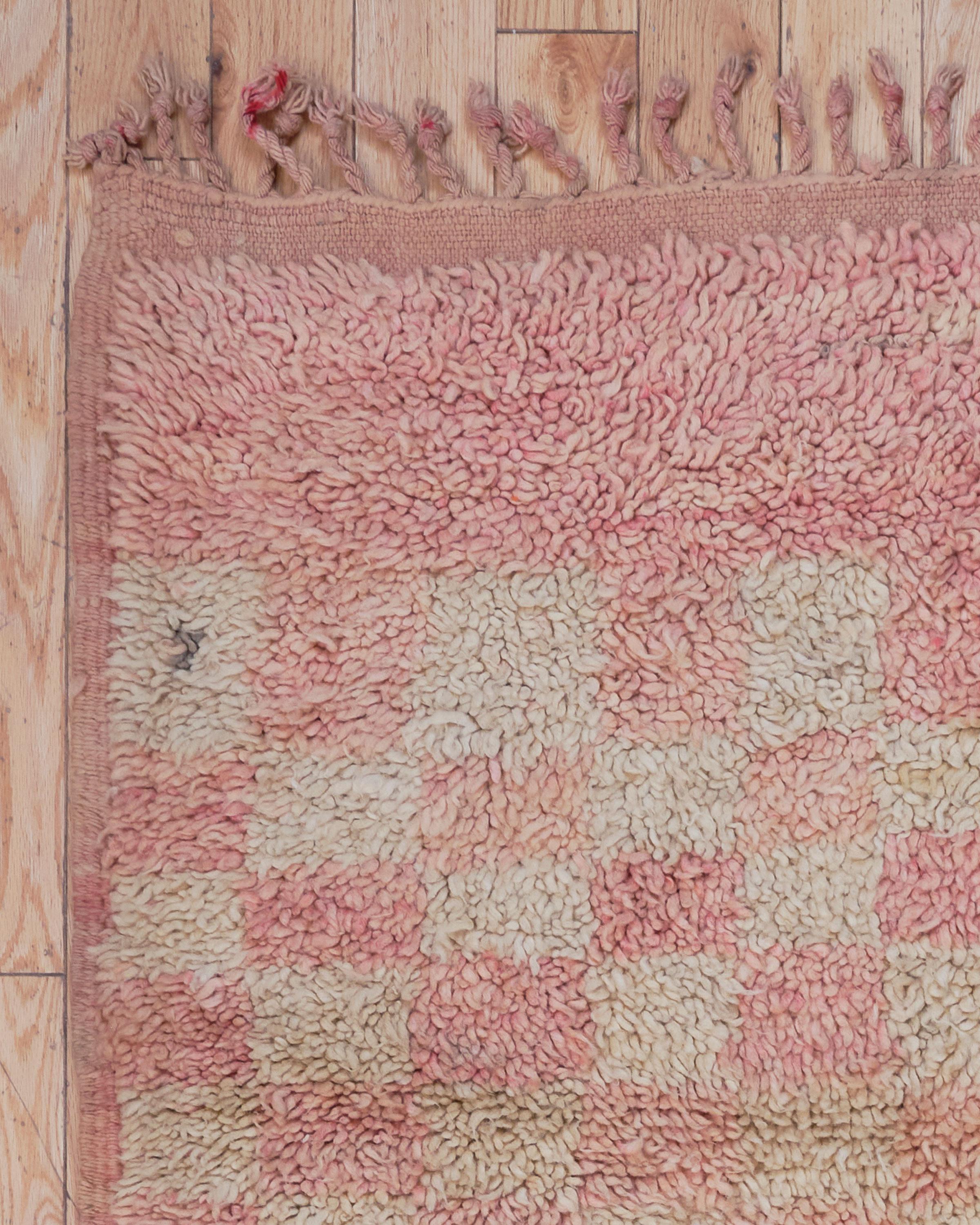 Le tapis Malika est une superbe pièce marocaine vintage, tissée à la main à partir de laine de mouton 100 % naturelle dans une délicate palette de rose blush et d'ivoire crémeux. Plein de charme féminin et de caractère intemporel, les teintes douces