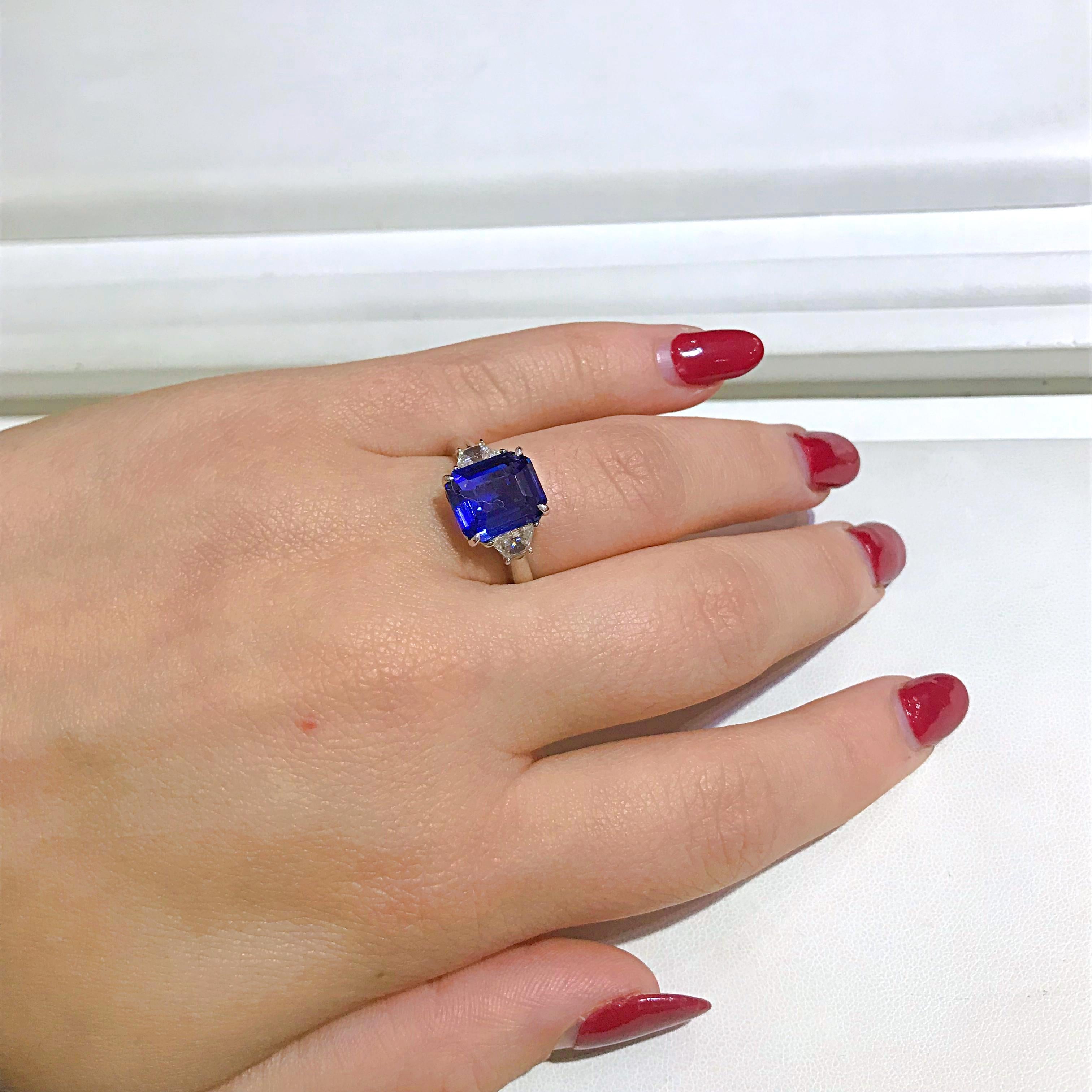 This classic style ring is a beautiful and elegant way to display a 5.11 carat Sapphire. The two trapezoid cut diamonds are a sparkling addition and total .52 carats total weight. The ring is crafted from platinum and is currently a size 8.5. This
