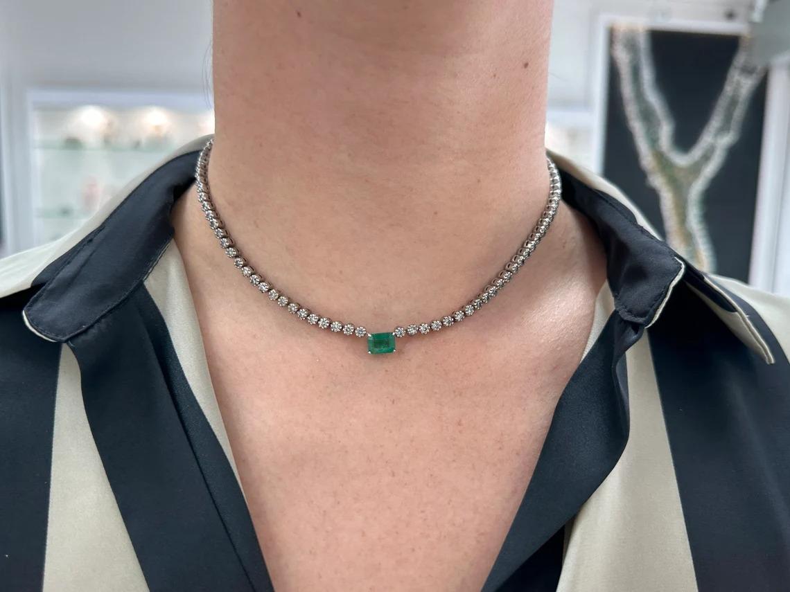 This necklace is not for the faint of heart! Featured here is a stunning emerald and diamond necklace made in fine 14K white gold. Displayed is a rich, dark green emerald cut emerald with good luster and clarity. Brilliant round diamonds are set in