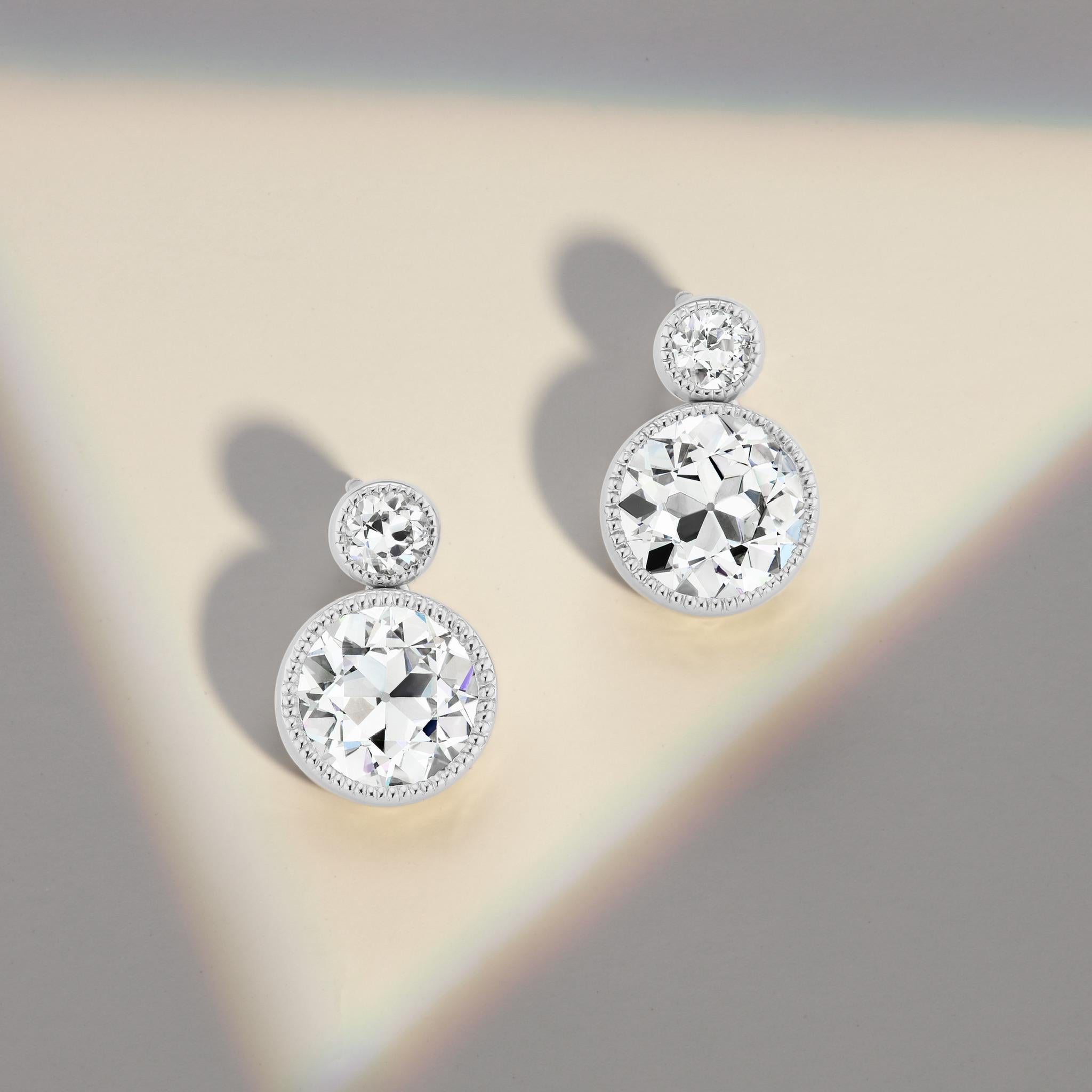 Old European Cut diamond and platinum earrings with a modern twist! These are not only spectacular and red carpet worthy, but also a perfect match of GIA certified H color VS1 clarity stones accented by matching 1/4 ct. stones. If you don't see