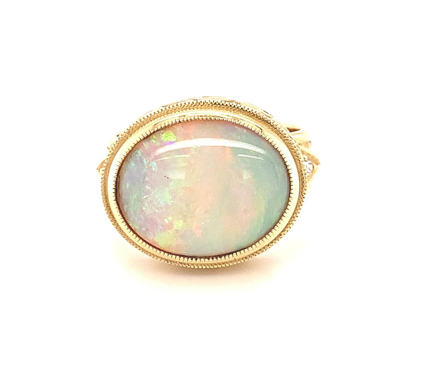 This beautiful 18k yellow gold handmade ring features a gorgeous Australian opal with stunning play-of-color.  Exhibiting all the colors of the rainbow in bright flashes throughout the entire gem, this opal ring will complement any outfit! The ring