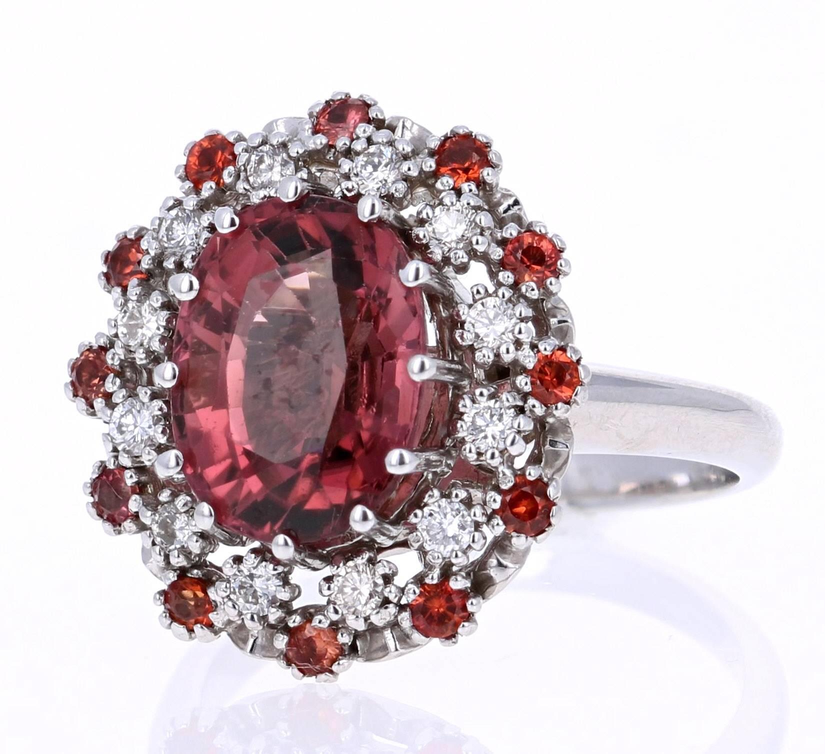 Stunning and uniquely designed 5.13 Carat Orange Sapphire Tourmaline Diamond White Gold Cocktail Ring!

This ring has a 4.46 carat Oval Cut Tourmaline that is set in the center of the ring and is surrounded by 12 Round Cut Orange Sapphires that