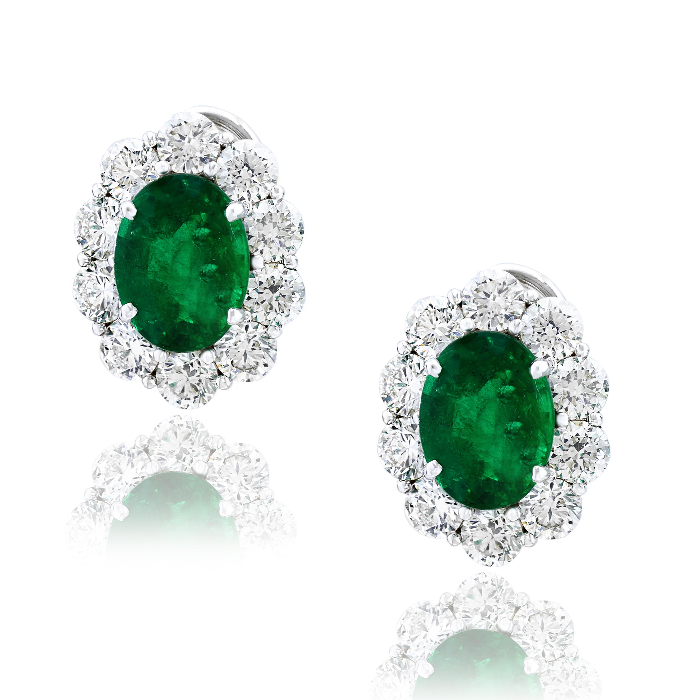 Showcasing two color-rich oval cut emeralds weighing 5.13 carats total, surrounded by a single row of round brilliant cut diamonds. 20 Accent diamonds weigh 3.86 carats total. Set in 18 karats white gold. Omega Clip with the post.

Style available