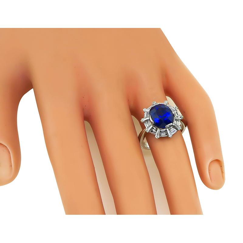 This is an amazing 18k white gold engagement ring. The ring is centered with a lovely oval cut sapphire that weighs approximately 5.13ct. The sapphire is accentuated by sparkling baguette cut diamonds that weigh approximately 1.50ct. The color of