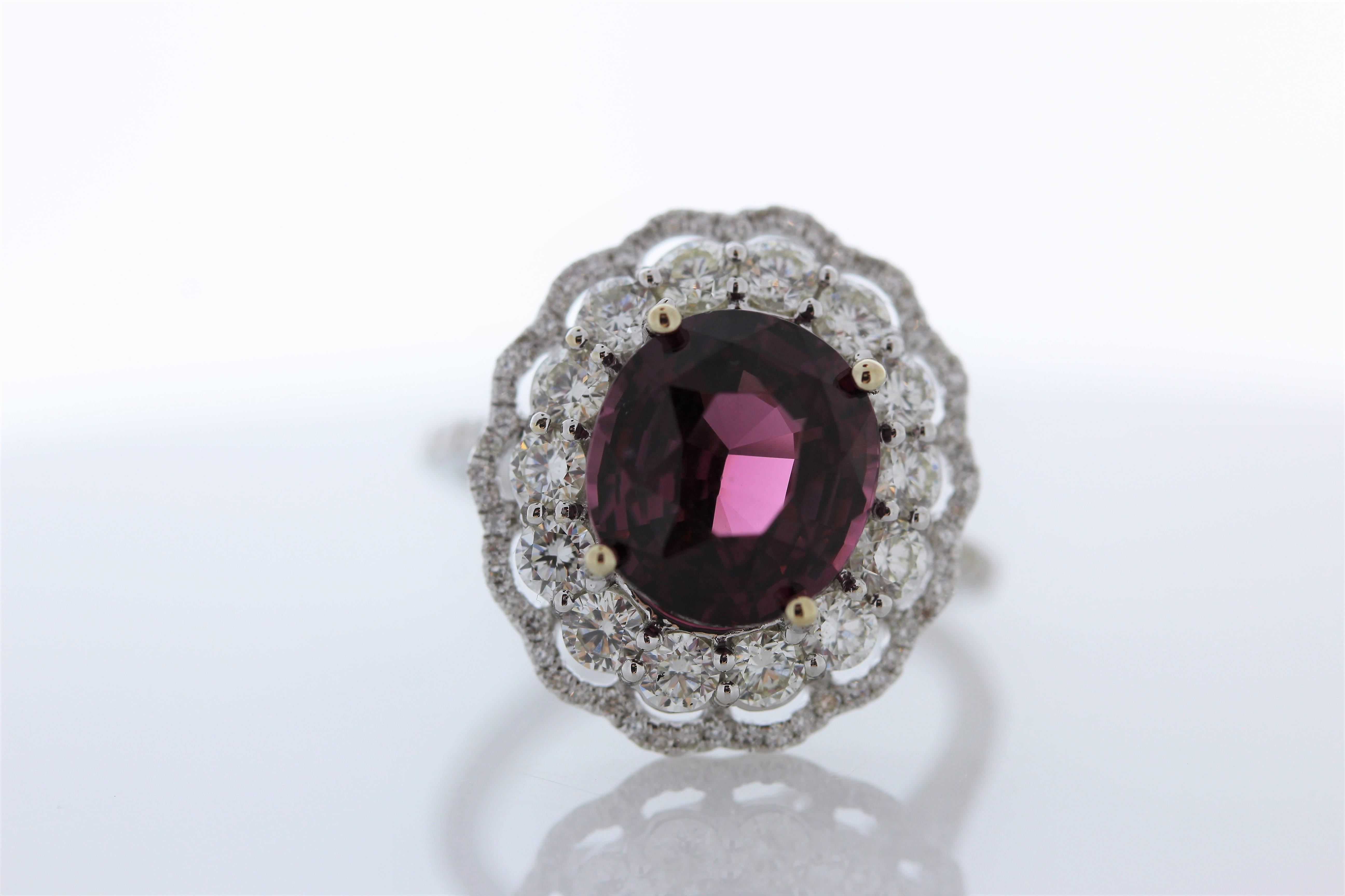This is a certified 5.13 carat fine round cut spinel. The gem source is Sri Lanka; its color is vivid purple pink. The bold color of this spinel is sought after and skillfully contrasted by 1.37carats of mixed cut brilliant diamonds that surround it