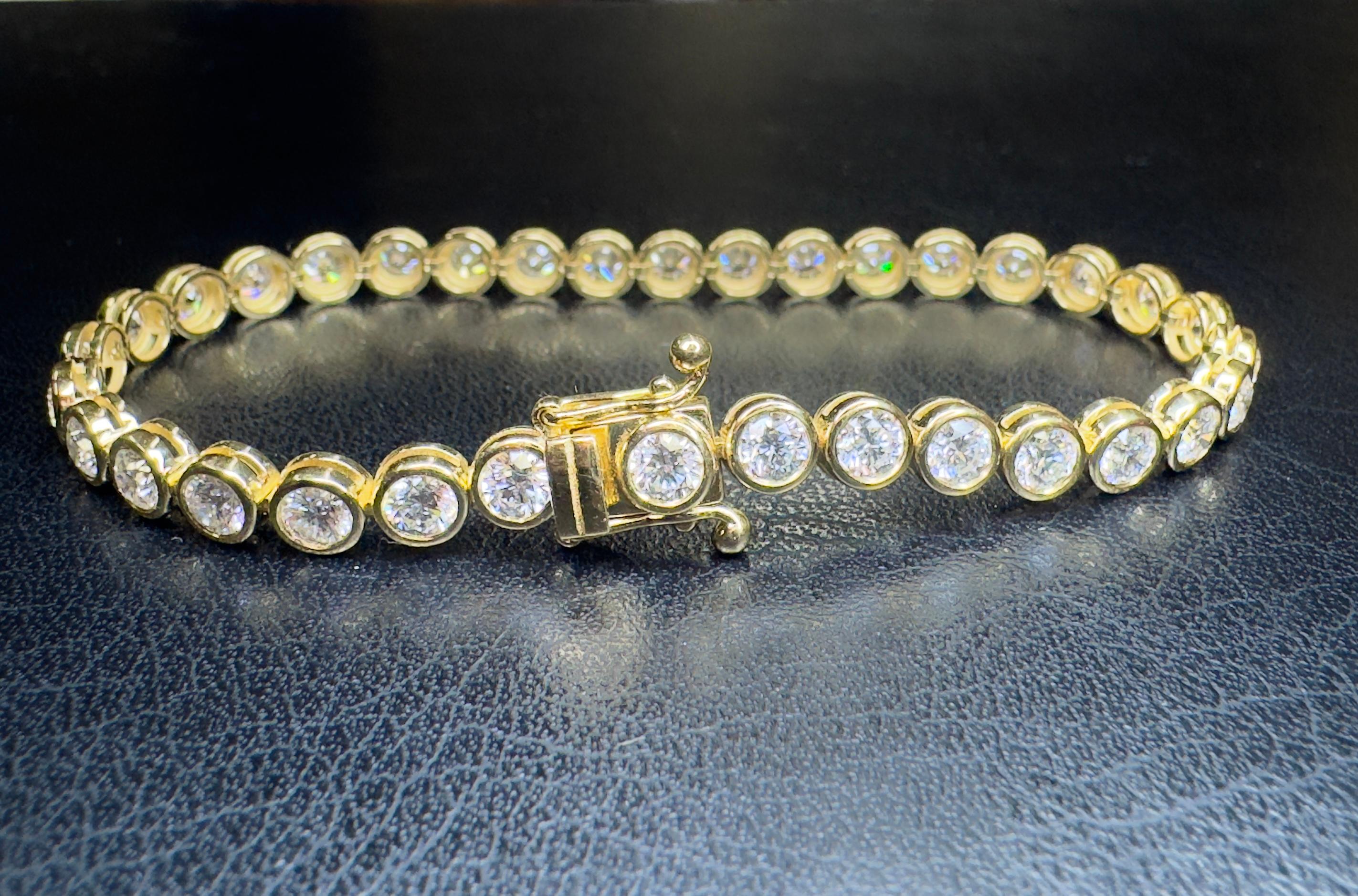 Elegant natural diamond tennis bracelet features 34 round brilliant diamonds, 5.40 carats. DEF color and VS1-SI1 clarity. Bezel set in 18 karat yellow gold with a double secured lock. Bracelet measures 6.75 inches in length and the total jewelry
