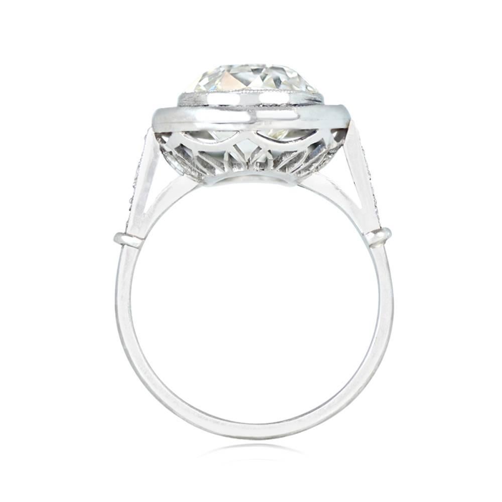 Cette magnifique bague de fiançailles à halo de saphir présente un diamant antique de taille coussin (couleur L, pureté VS2) pesant environ 5,15 carats, complété par des saphirs naturels de taille française. La bague en platine est ornée d'un motif