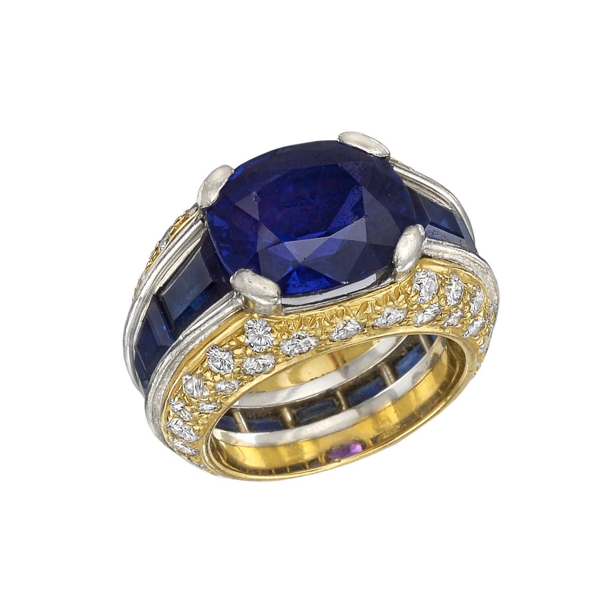 Domed cocktail ring, centering an oval-shaped faceted color-change blue/purple sapphire weighing approximately 5.15 carats, flanked by calibre-cut blue sapphires and round brilliant-cut diamonds, mounted in 18k yellow gold and platinum.

Twelve