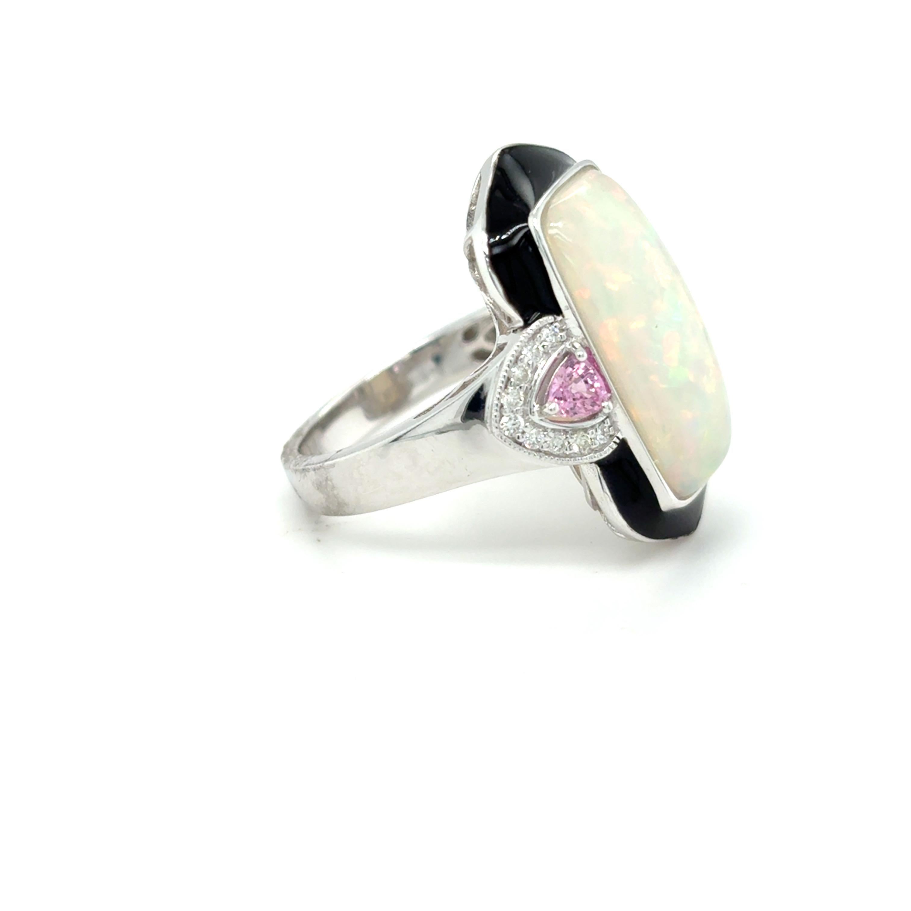 This striking 5.16-carat baguette opal is flanked by two vibrant triangular pink sapphires, each accented by a halo of sparkling white diamonds. The center stone is beautifully framed with bold black enamel detailing that makes the opal’s