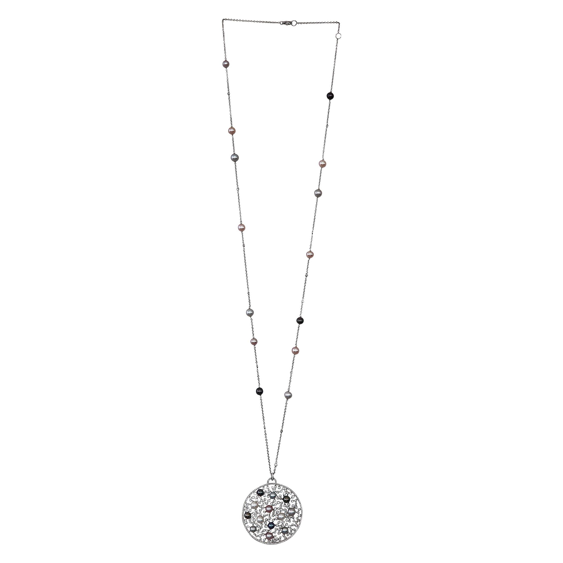 A wonderful necklace characterized by a round element with a constellation of white round brilliant diamonds and multi colored pearls, nuanced from white to dark grey.
Diamonds are color G clarity SI and the total weight is 5,16 carats, there are a