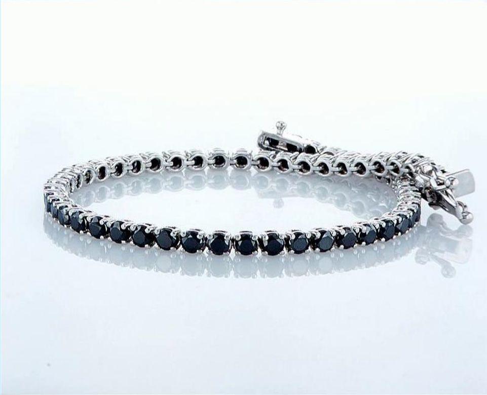 Our hand crafted Black Diamonds Tennis Bracelet is set with 57 round cut black diamonds 5.17 Total diamond weight. 
The timeless bracelet is set in a 4 prong setting and crafted in 14K white Gold.  
Bracelet length is 7.6 inches 
Our bracelet closes