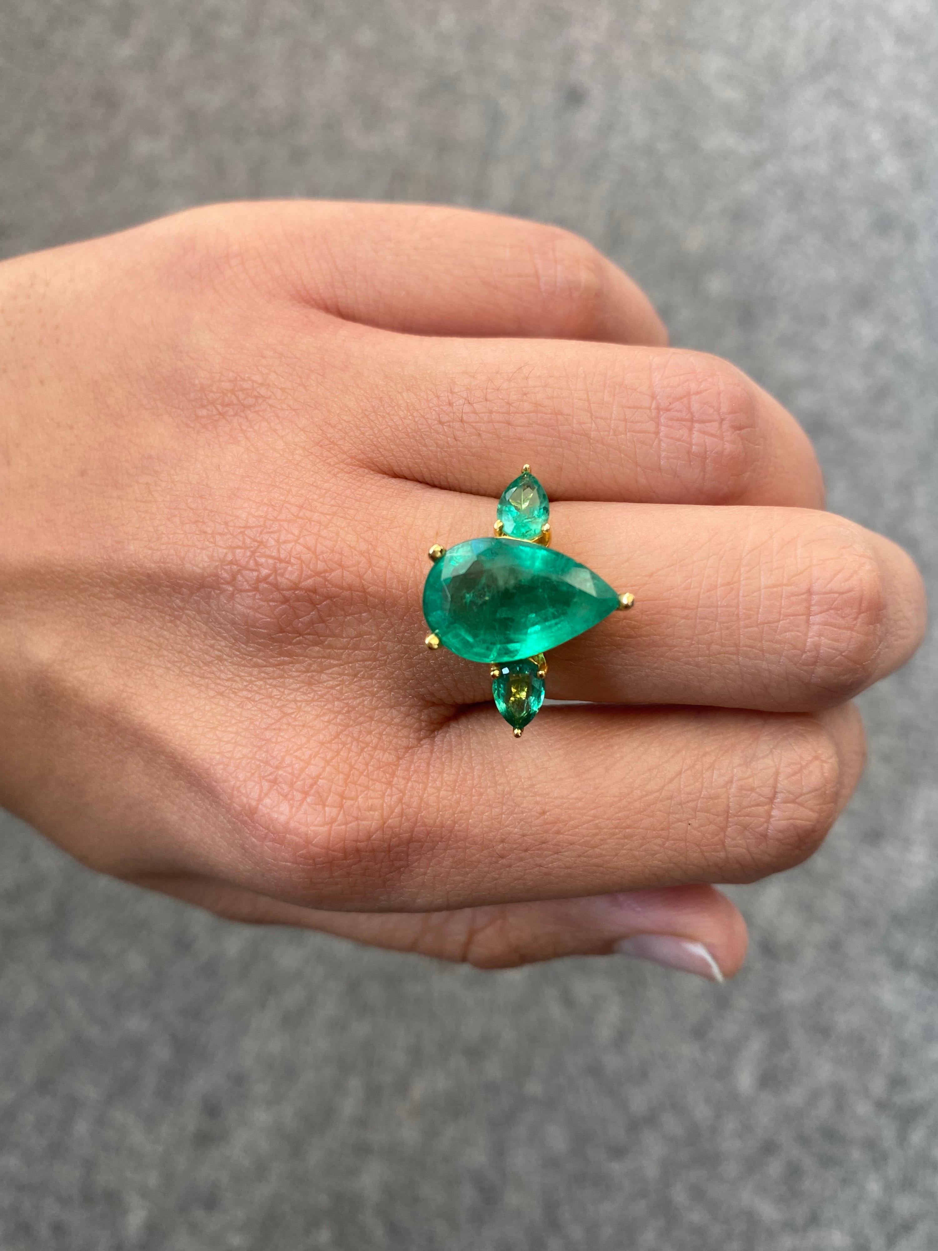 A gorgeous, all Emerald three-stone engagement ring. With a 5.17 carat pear shape Emerald in the centre, with 2 pieces 0.9 carat pear shape Emeralds on the side. The Emeralds are Zambian origin, with a beautiful vivid green color, transparent and