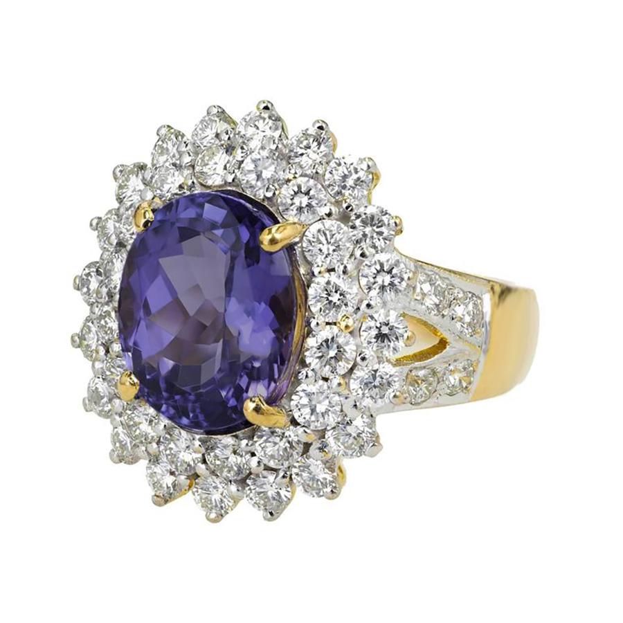 Stunning 5.17 Carat oval purple blue tanzanite diamond halo cluster cocktail ring.  Its exquisite oval cut tanzanite gemstone, boasting a unique fusion of purple and blue hues, is framed by two glittering halo's of round cut diamonds which is